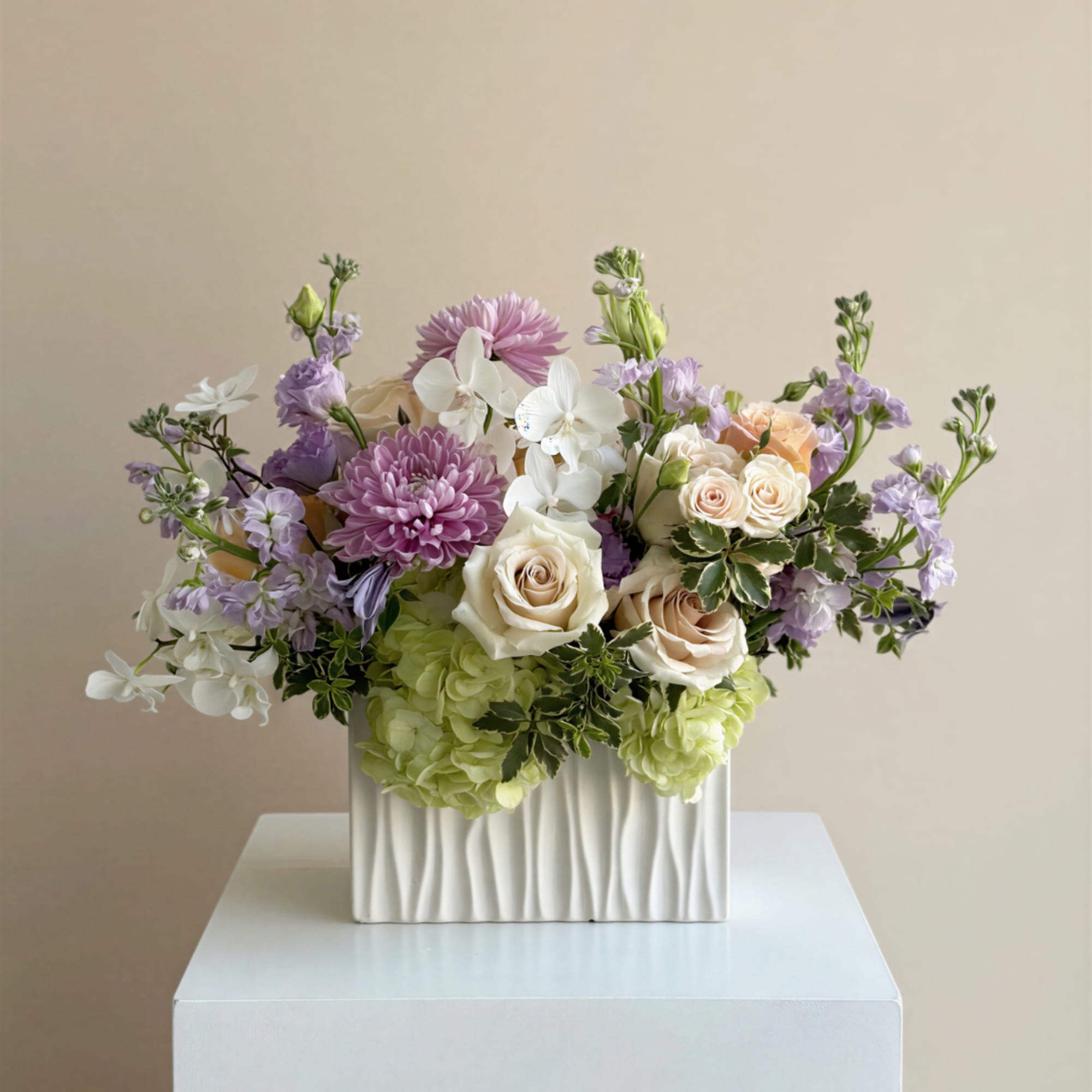 Pastel floral arrangement in a white rectangular vase