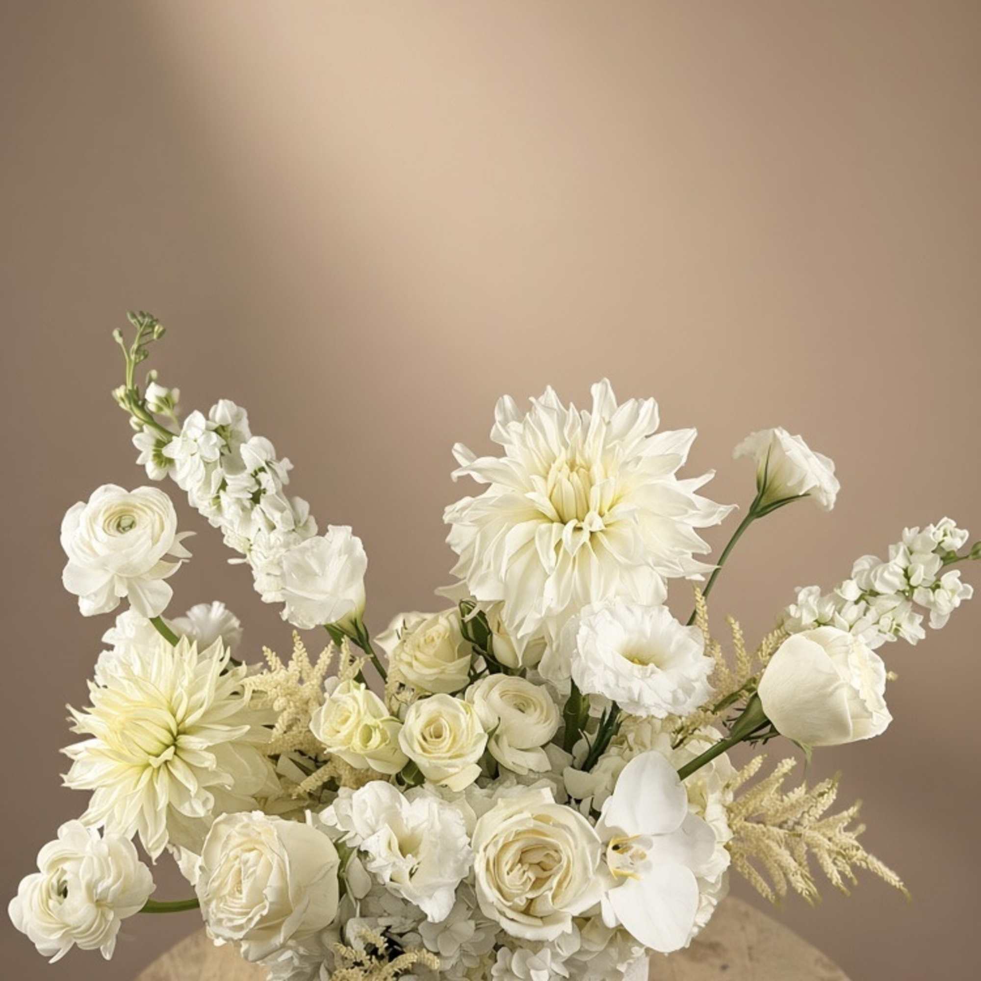 White floral arrangement in a round vase on a wooden table