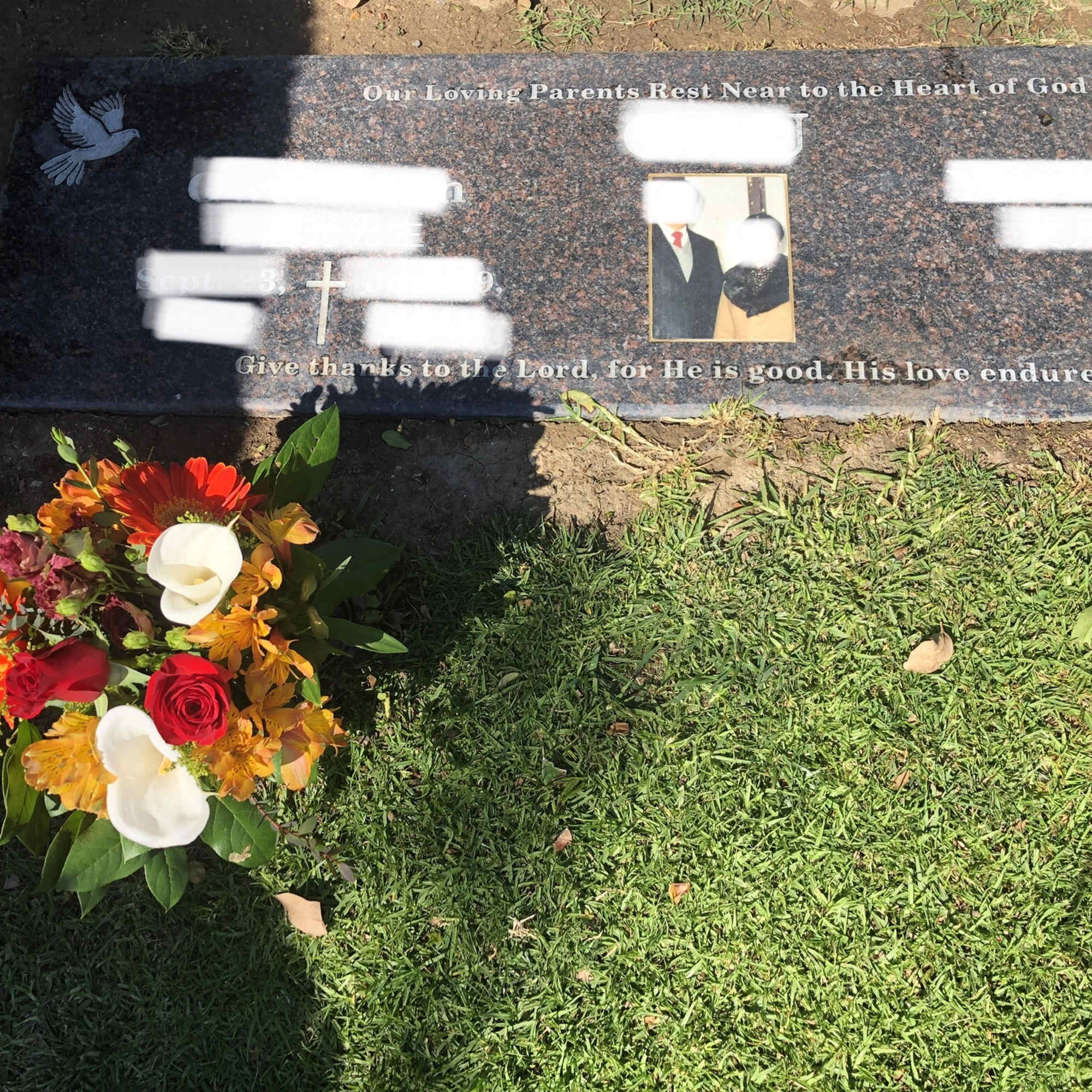 Colorful floral arrangement placed beside a gravestone