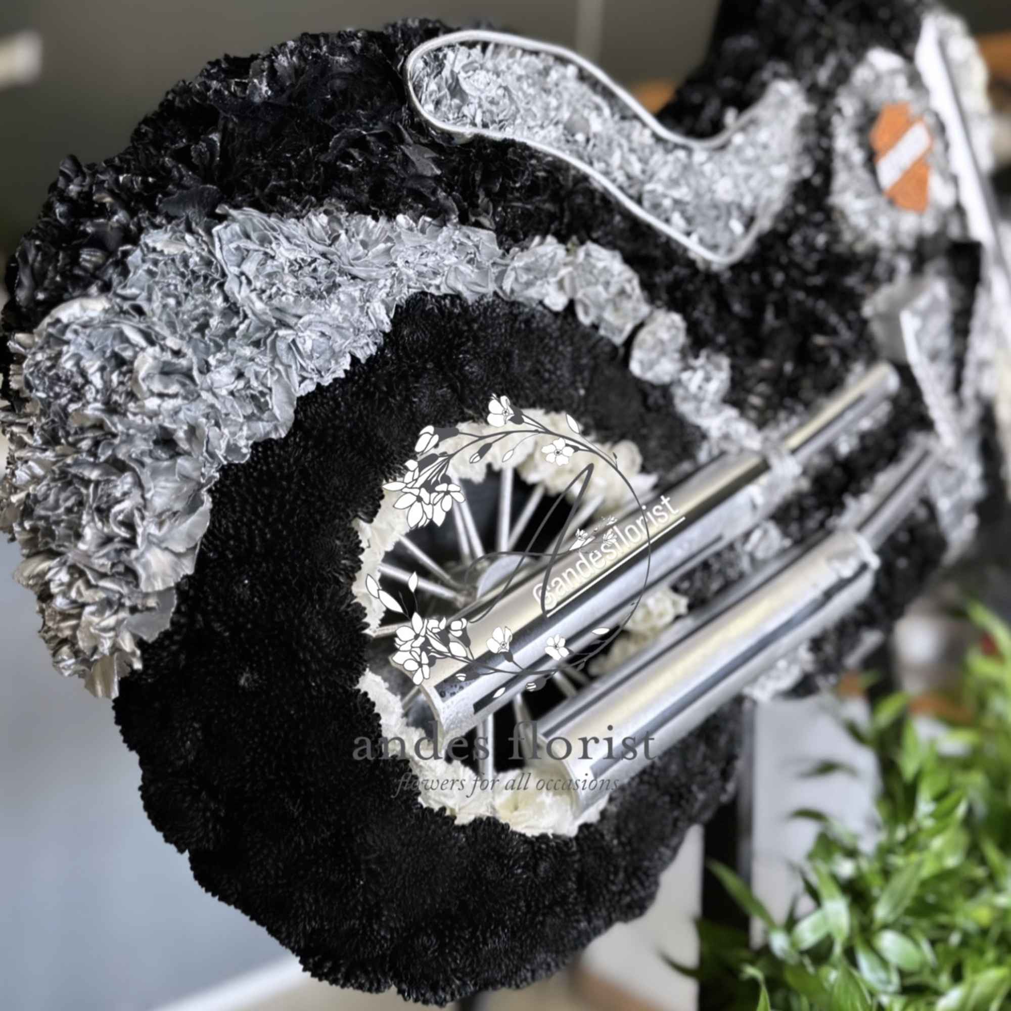 Black and silver floral wreath with a wheel-like center