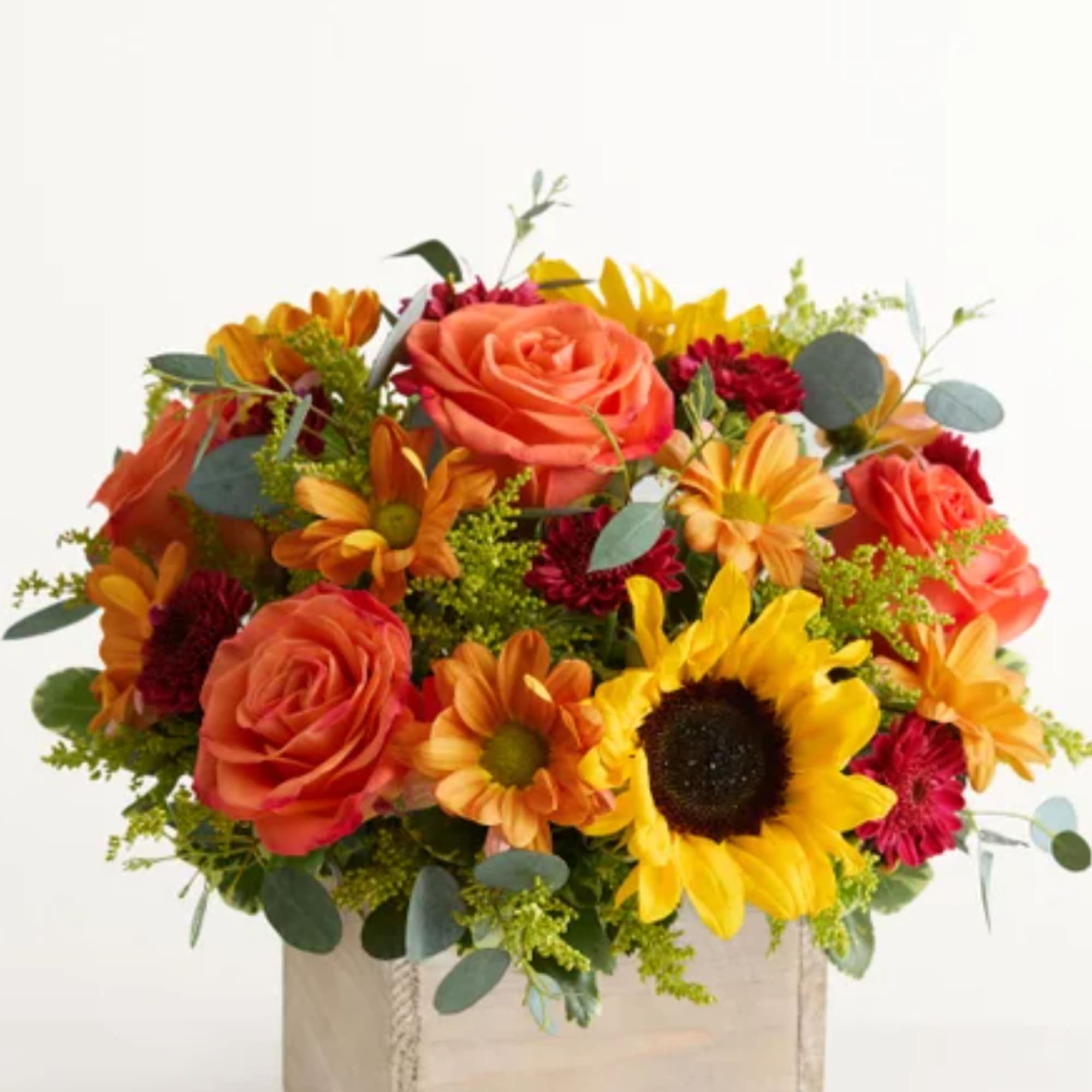 Bouquet of orange roses, sunflowers, and red daisies in a box