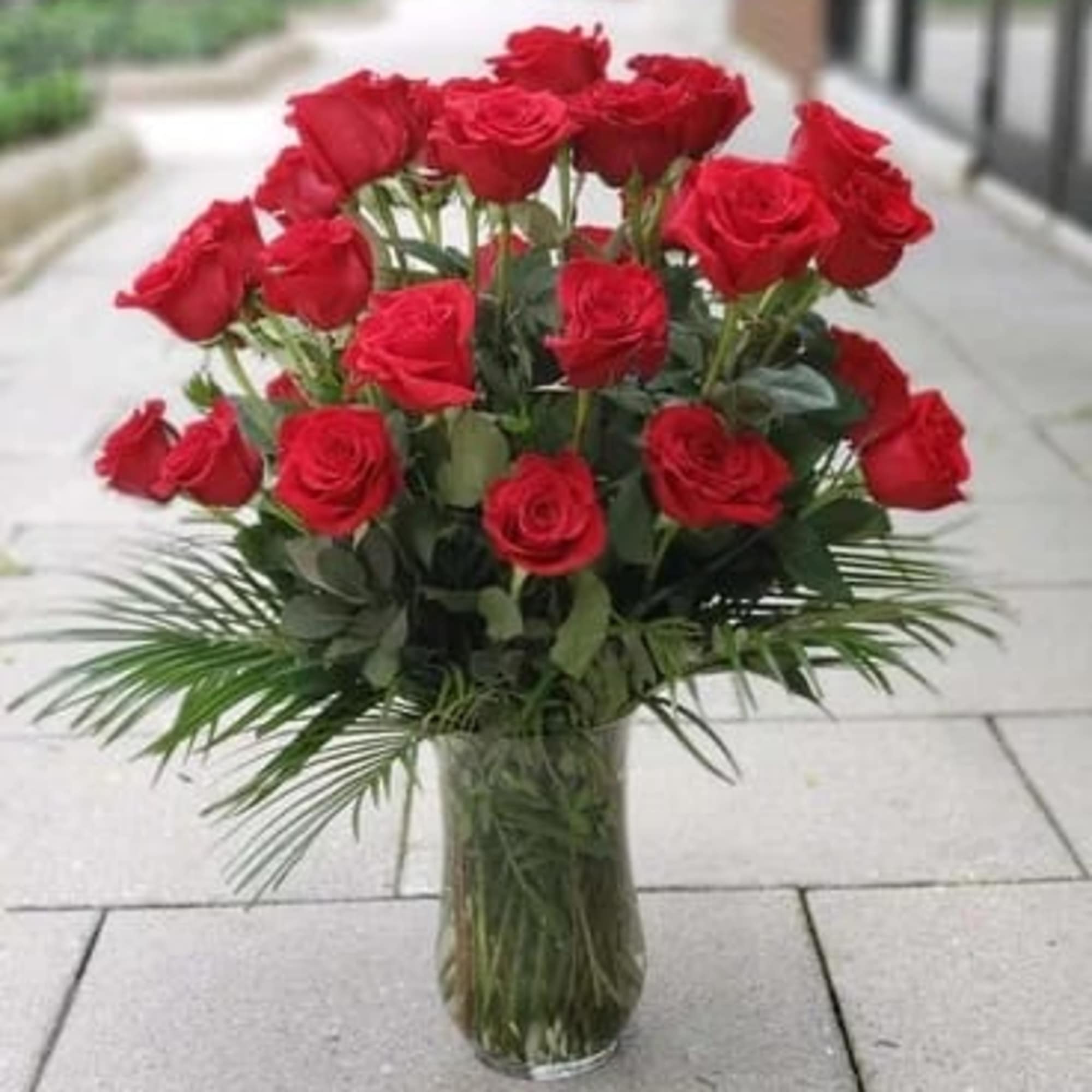Red roses arranged in a clear glass vase