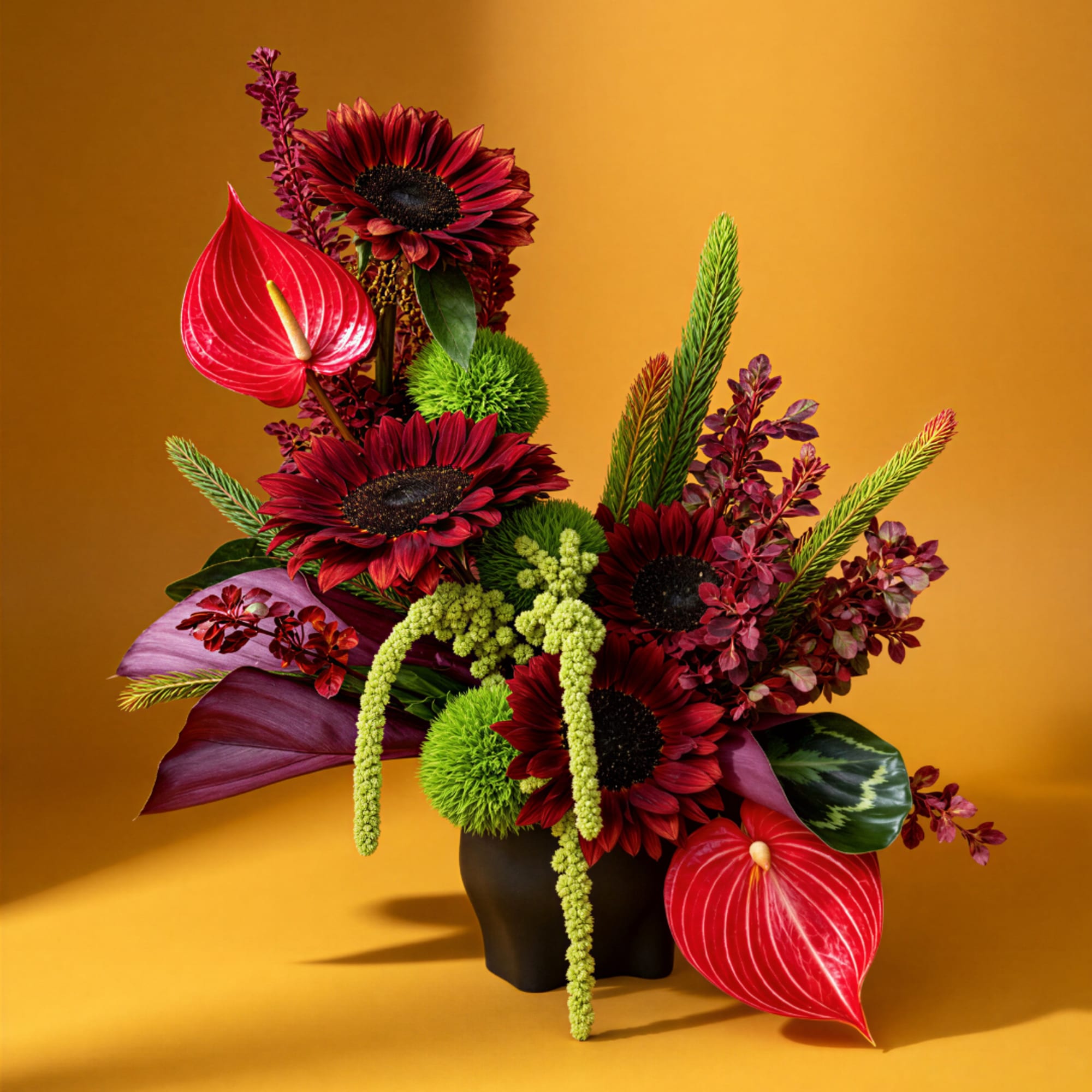 Bold floral arrangement with red blooms and a dark vase on a gold background.