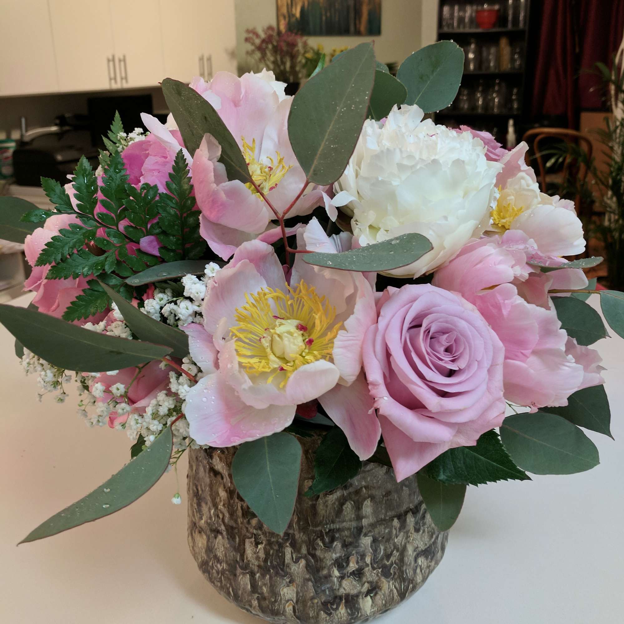 Pink and white floral arrangement in a textured vase