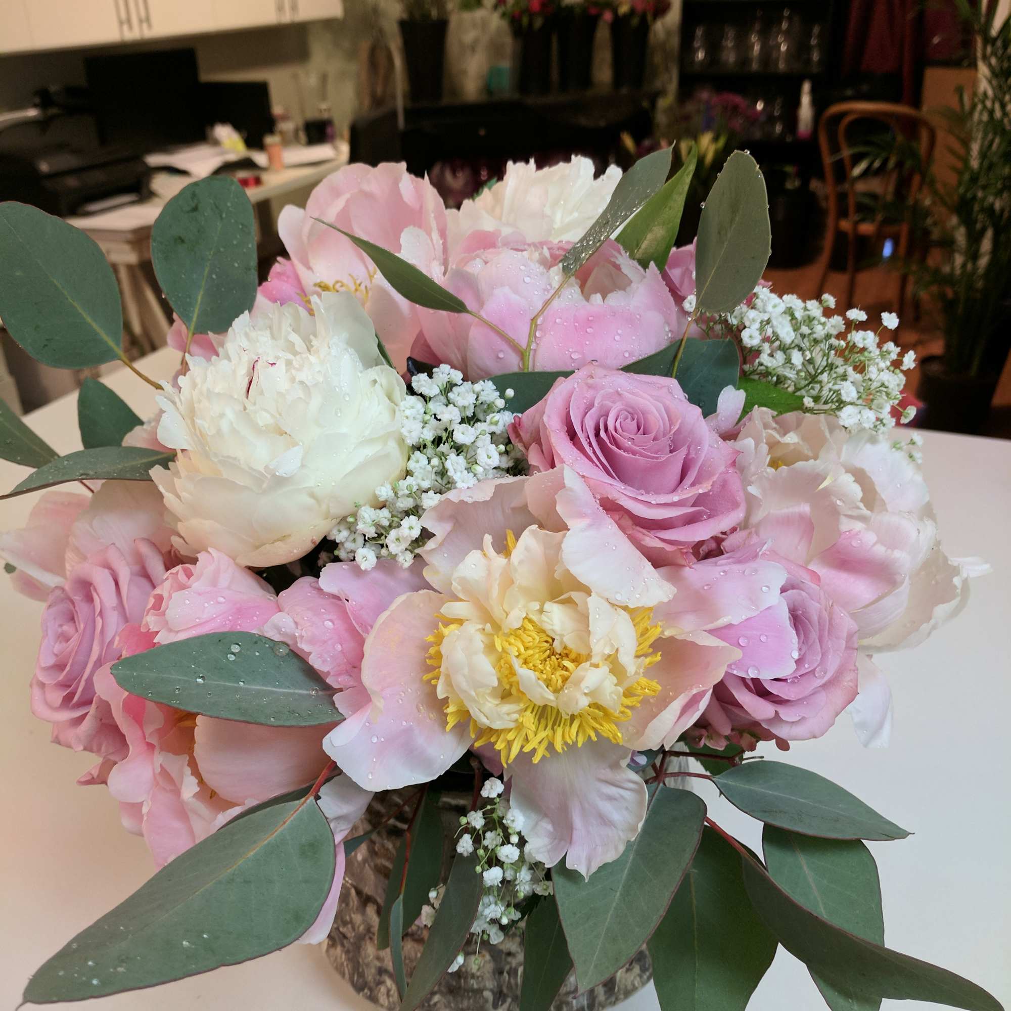 Pink and white floral arrangement in a low vase with eucalyptus