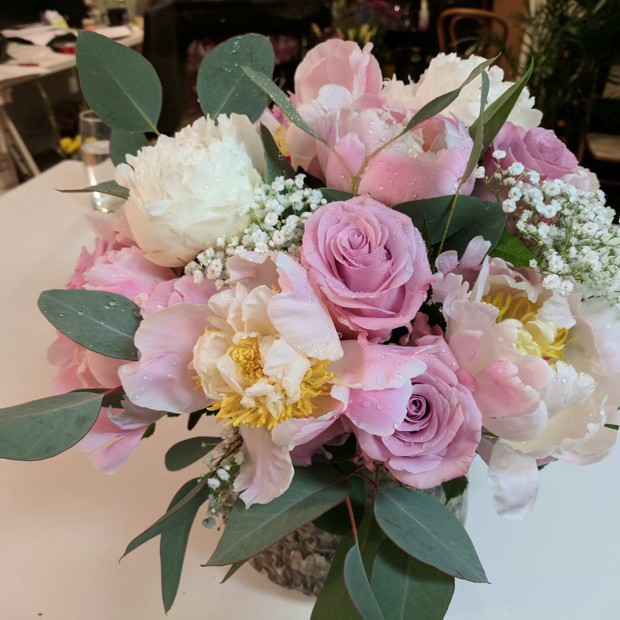 Pink and white bouquet with roses and peonies in a glass vase