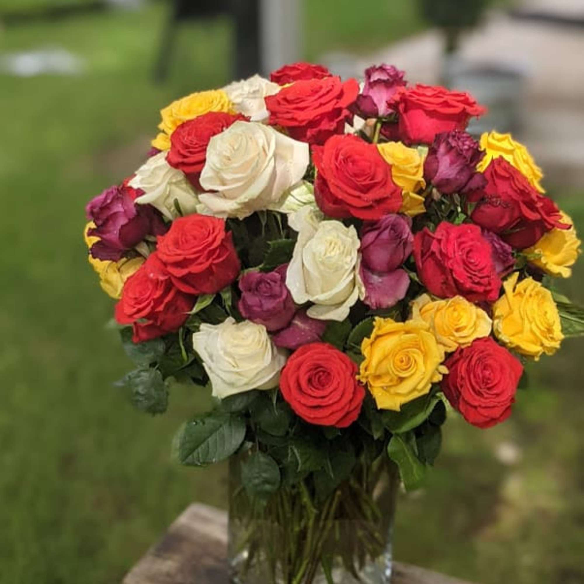Bouquet of multicolored roses in a clear glass vase, photo 2 of 4