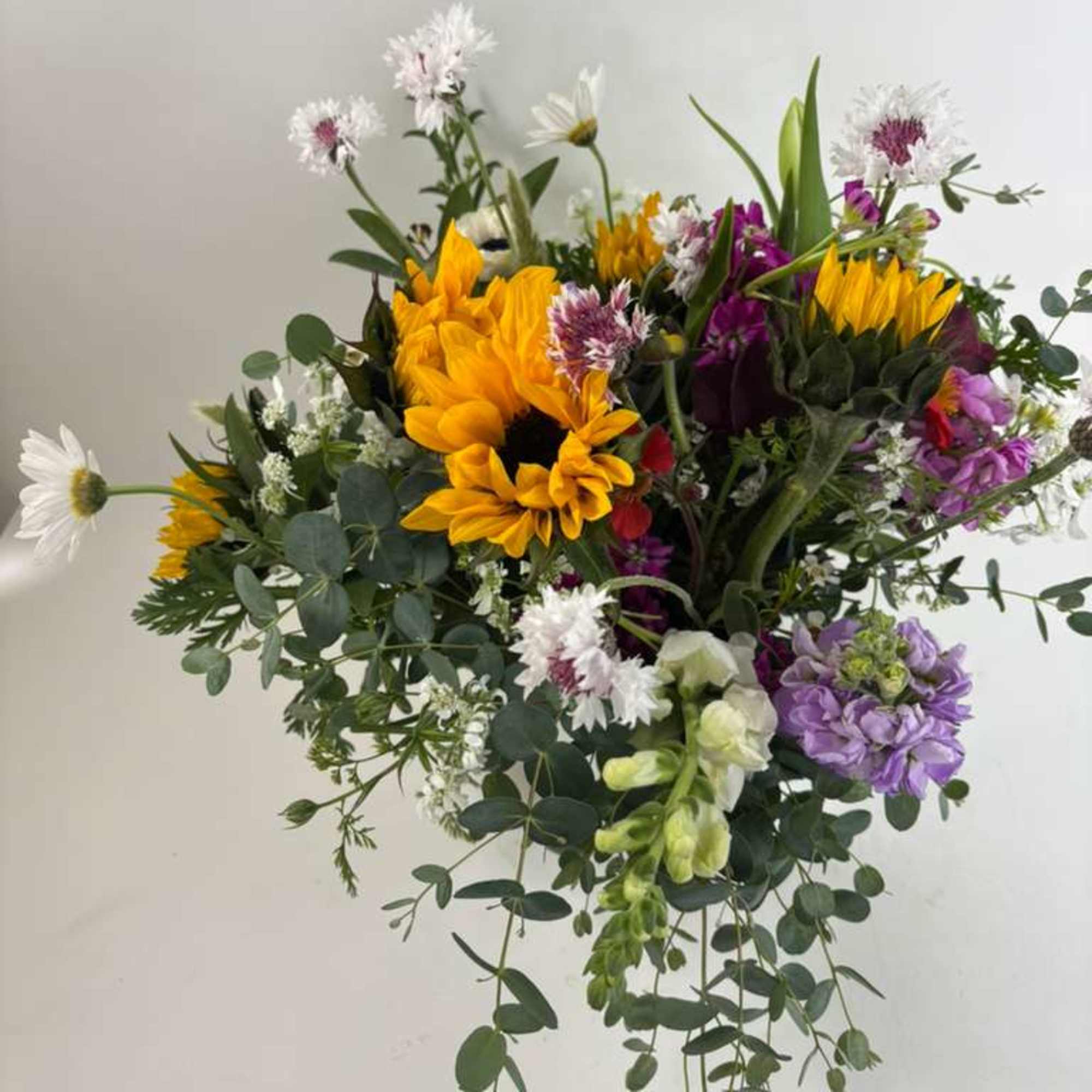 Mixed bouquet with sunflowers, purple blooms, and white daisies