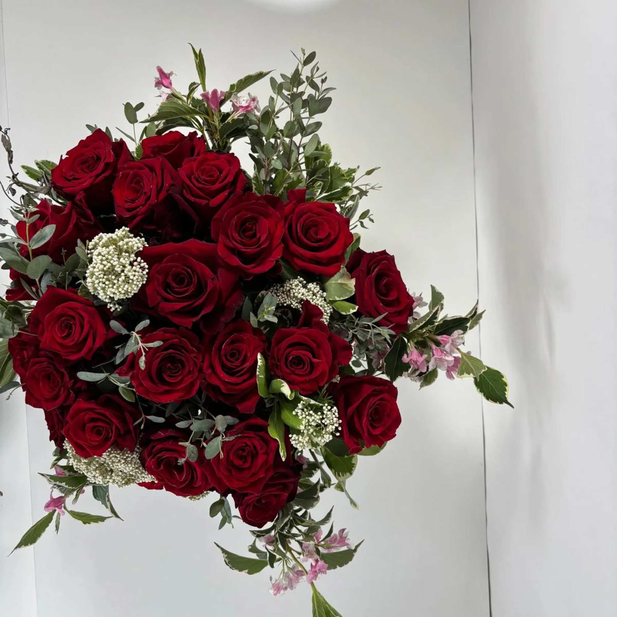 Bouquet of red roses with white filler flowers and mixed greenery