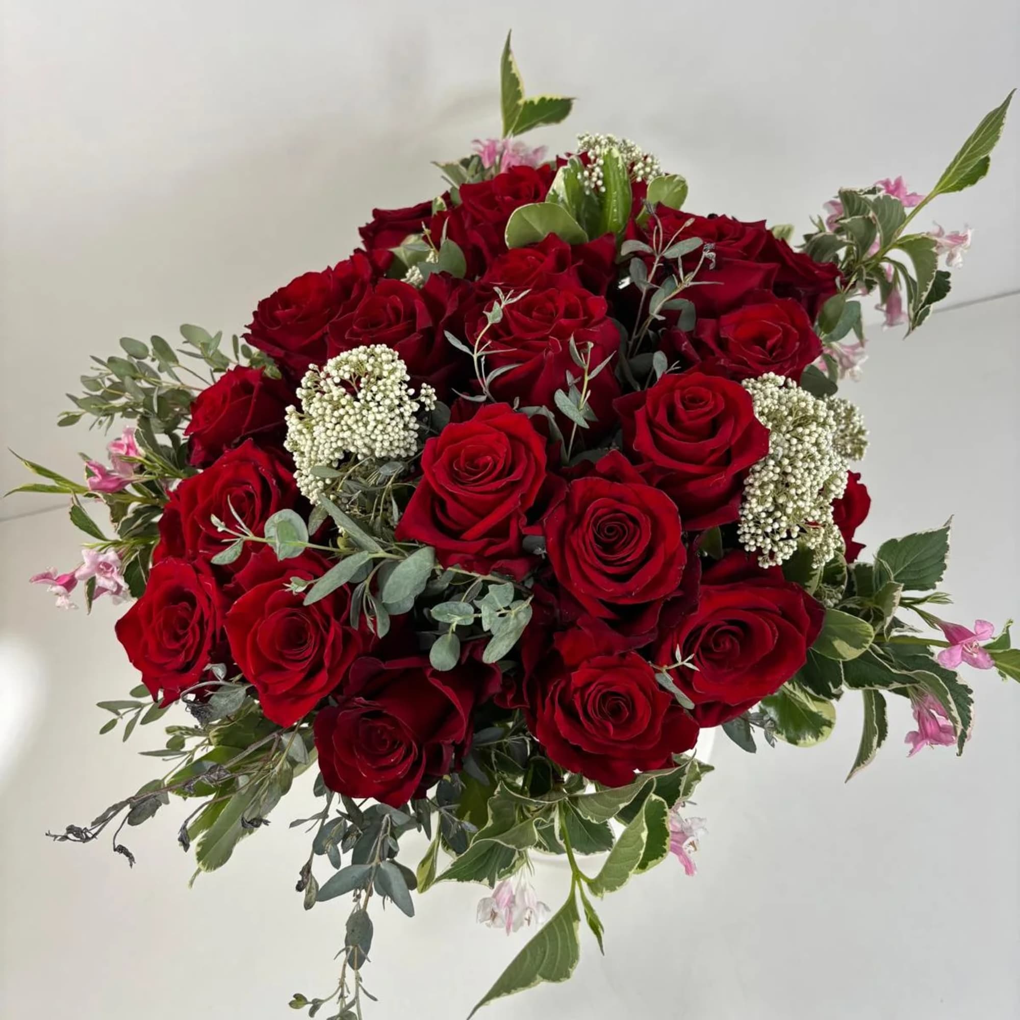 Bouquet of red roses with small white filler flowers and mixed greenery