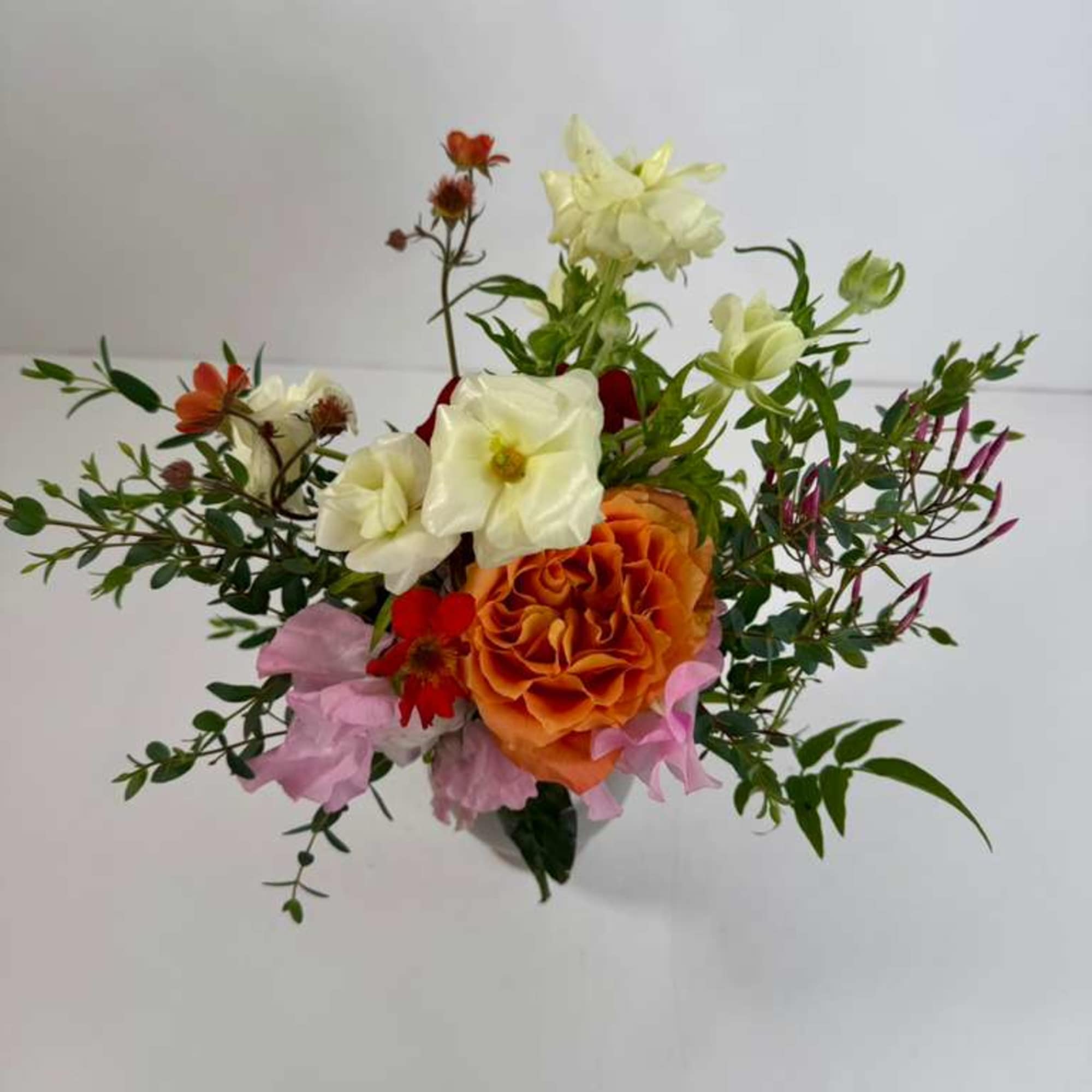 Mixed bouquet with orange, white, pink, and red flowers