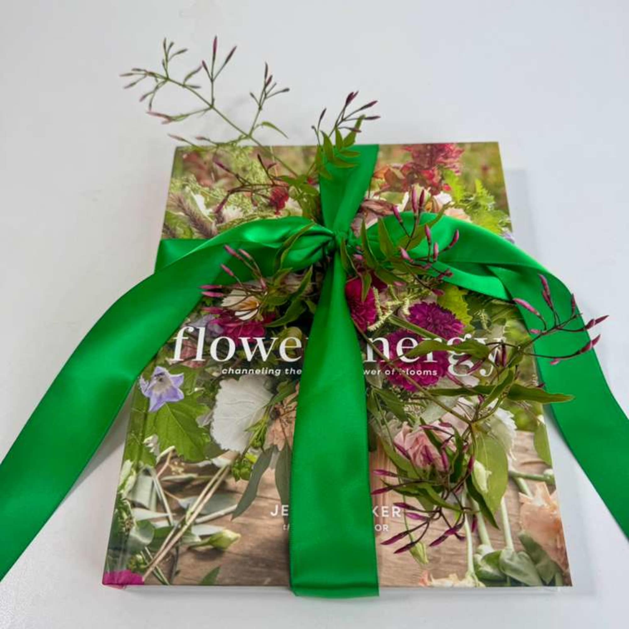 Gift book wrapped with a bright green ribbon and floral sprigs
