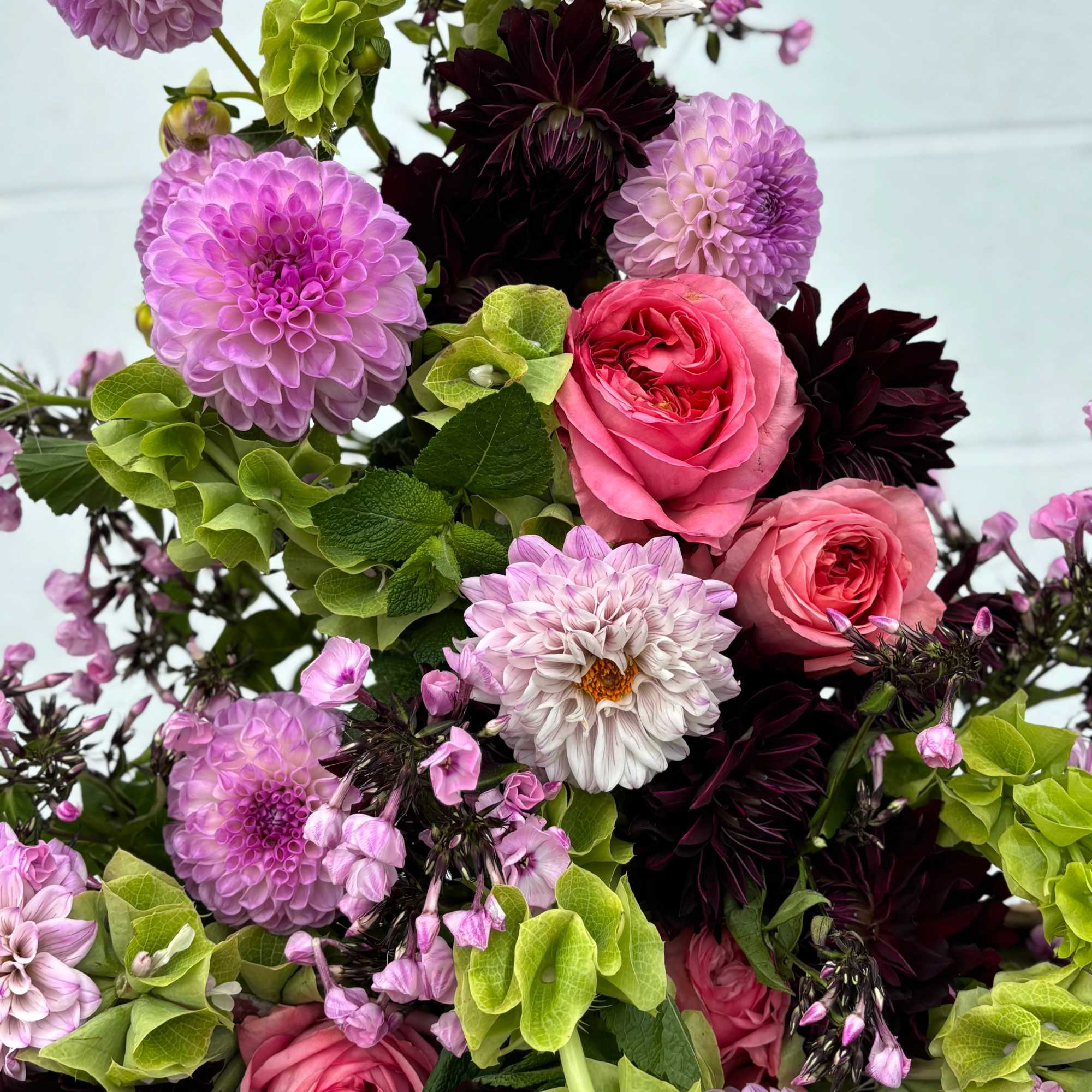 Bouquet of pink roses, lavender dahlias, and green hydrangeas