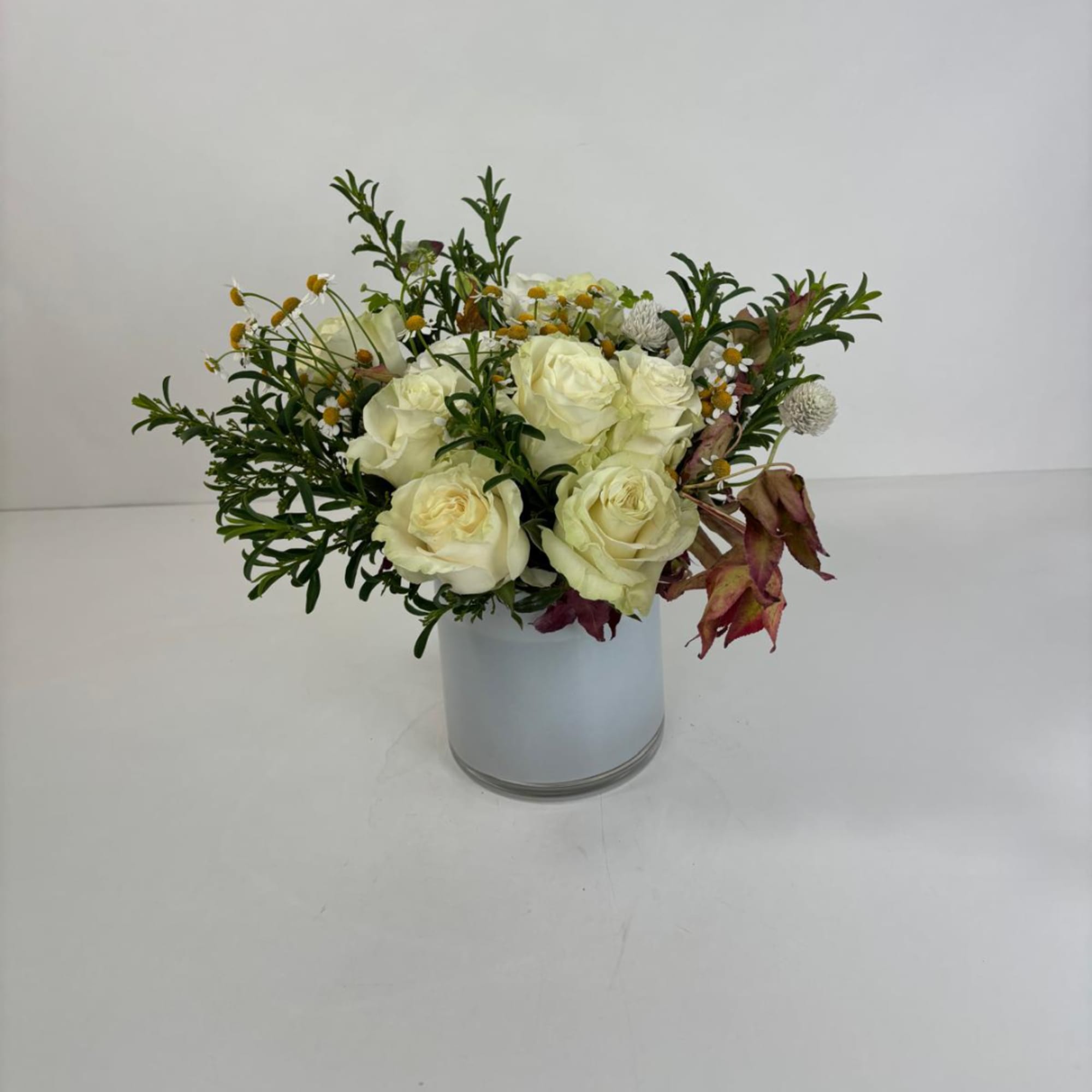 White rose arrangement in a white cylindrical vase