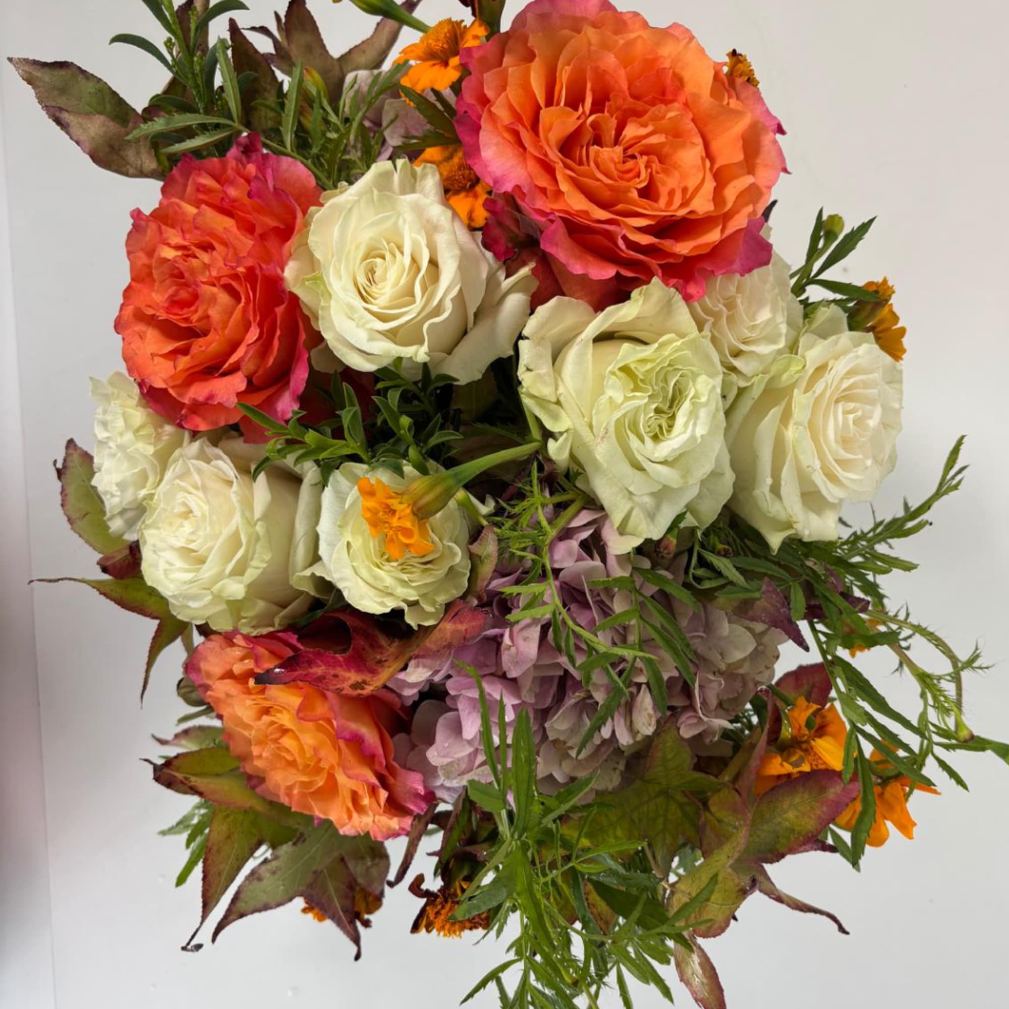 Bouquet of orange and white roses with purple hydrangea