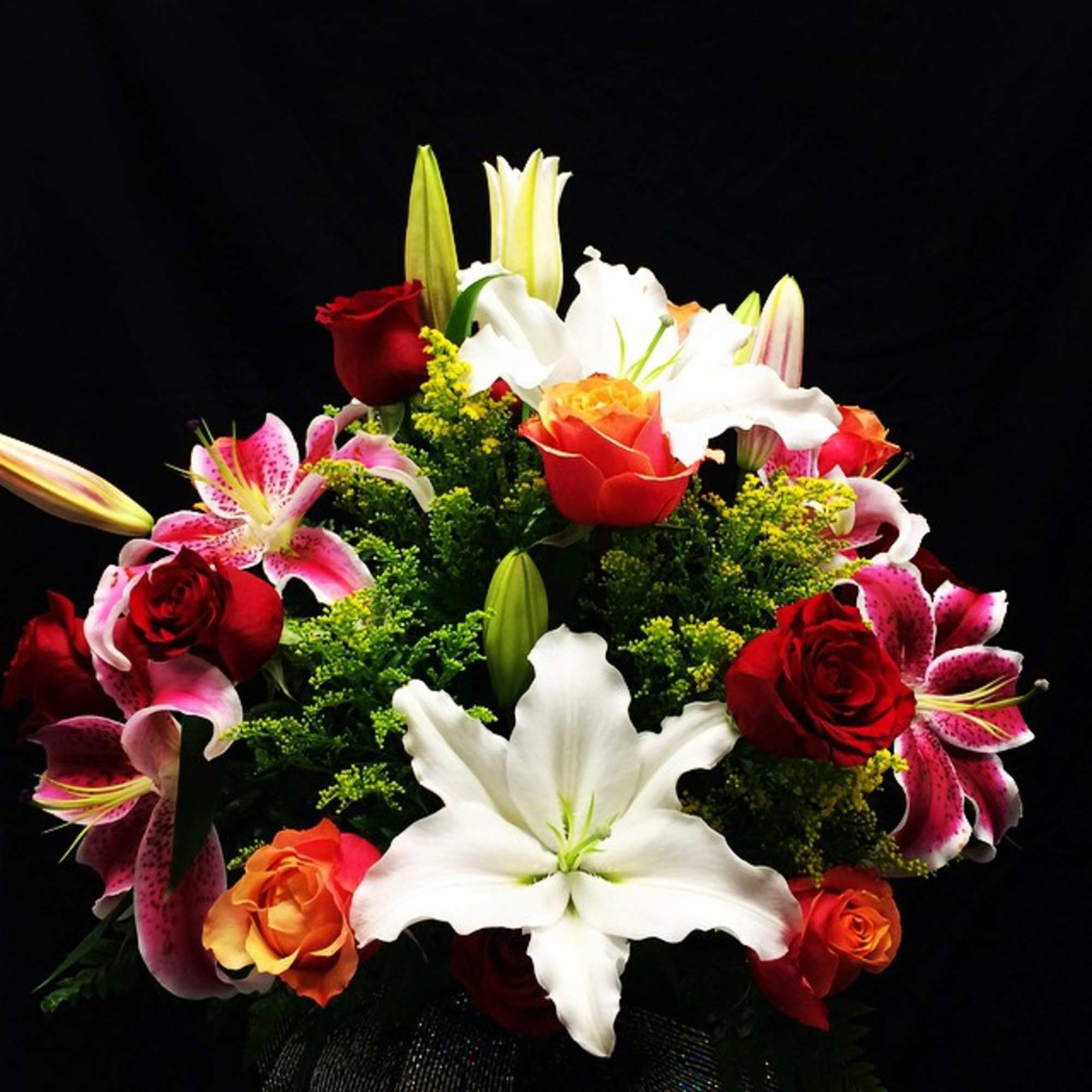 Mixed bouquet of lilies and roses in red, white, and pink