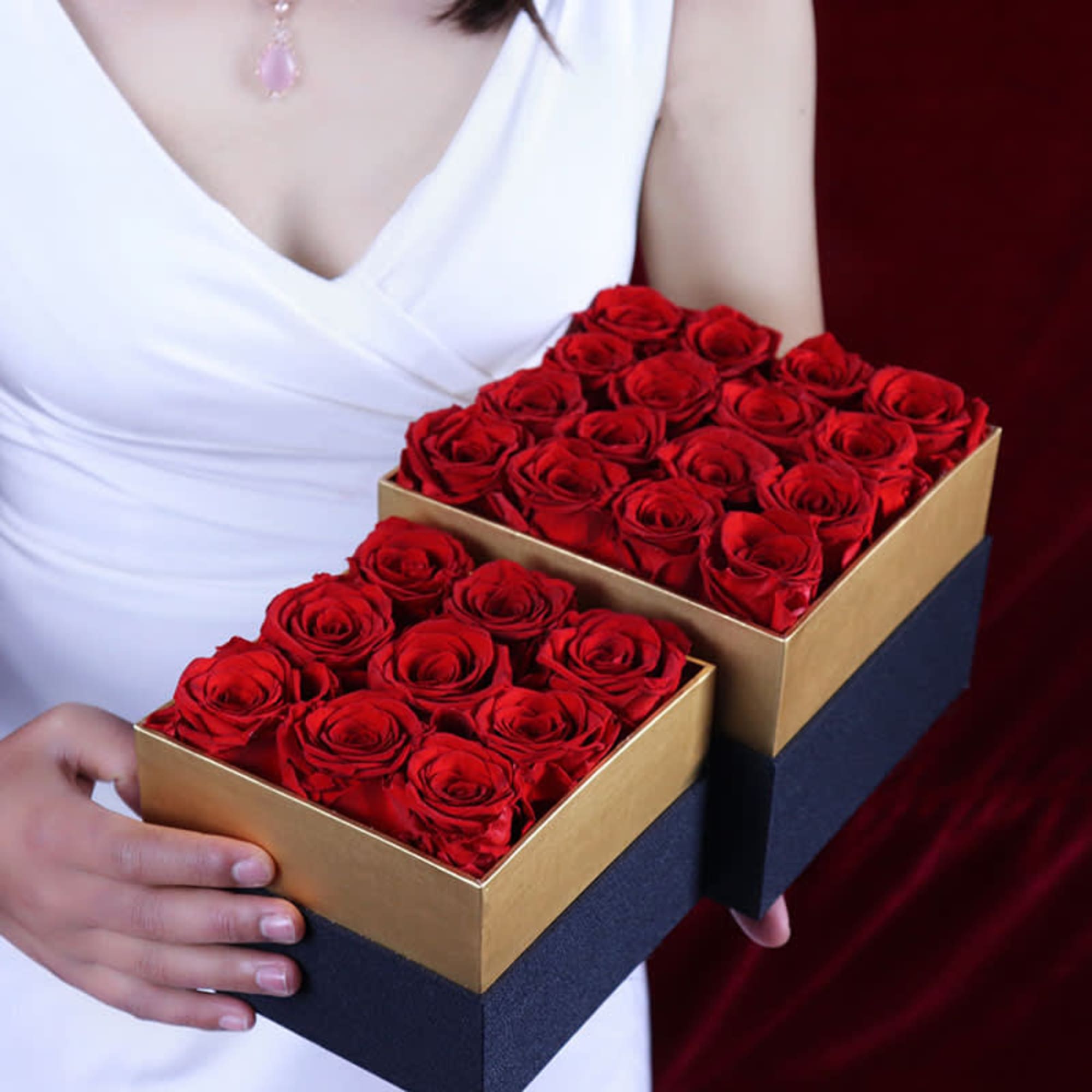 Woman holding two boxes of red roses