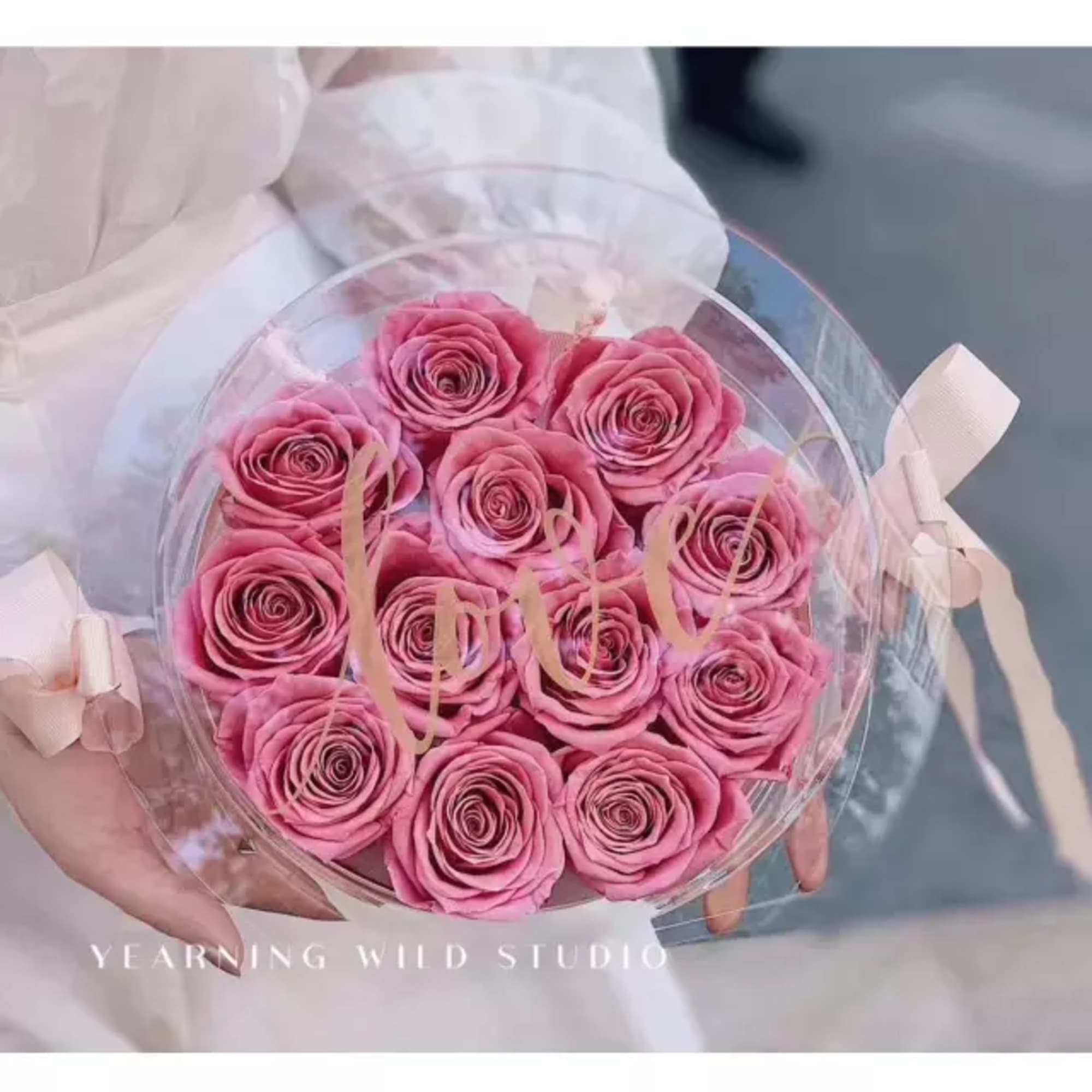 Round bouquet of pink roses wrapped in clear plastic