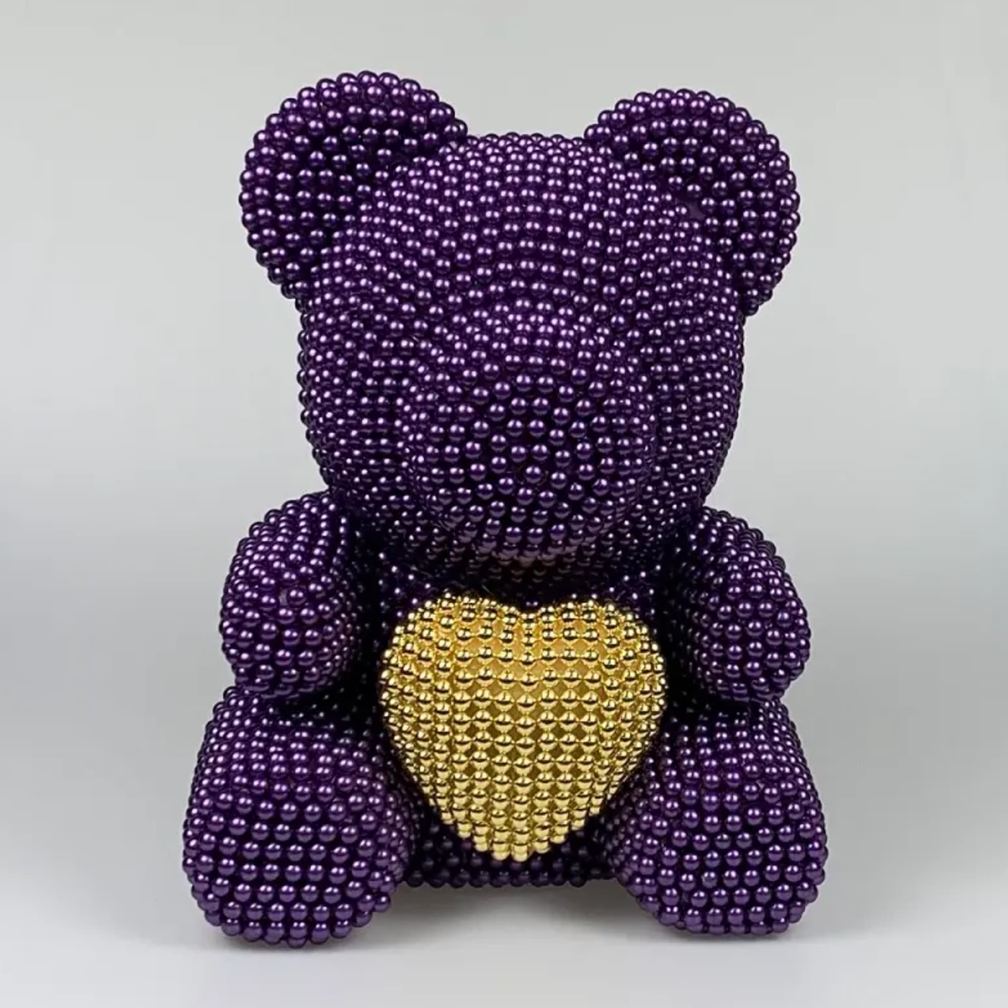 Purple beaded teddy bear holding a gold heart