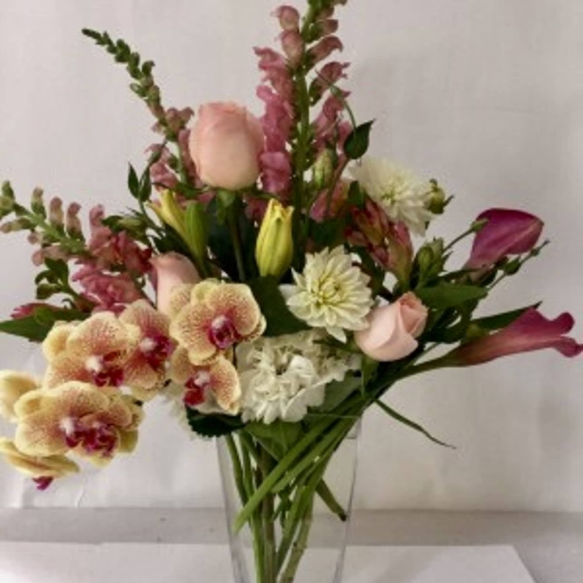 Mixed bouquet in a clear glass vase with pink and white flowers