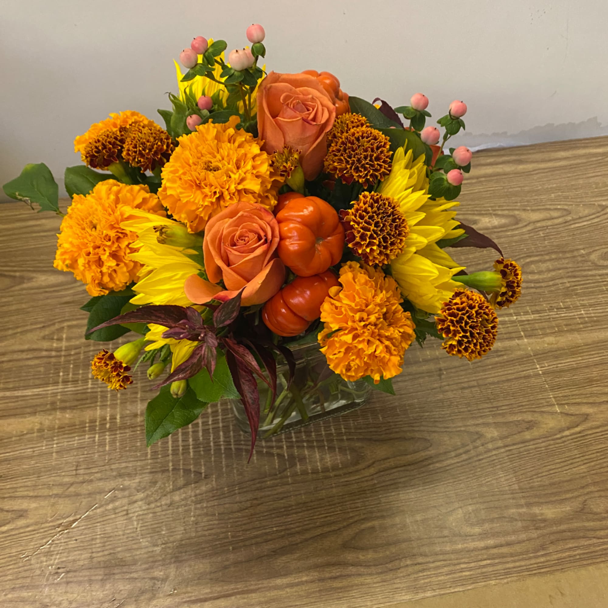 Orange and yellow floral arrangement in a clear glass vase