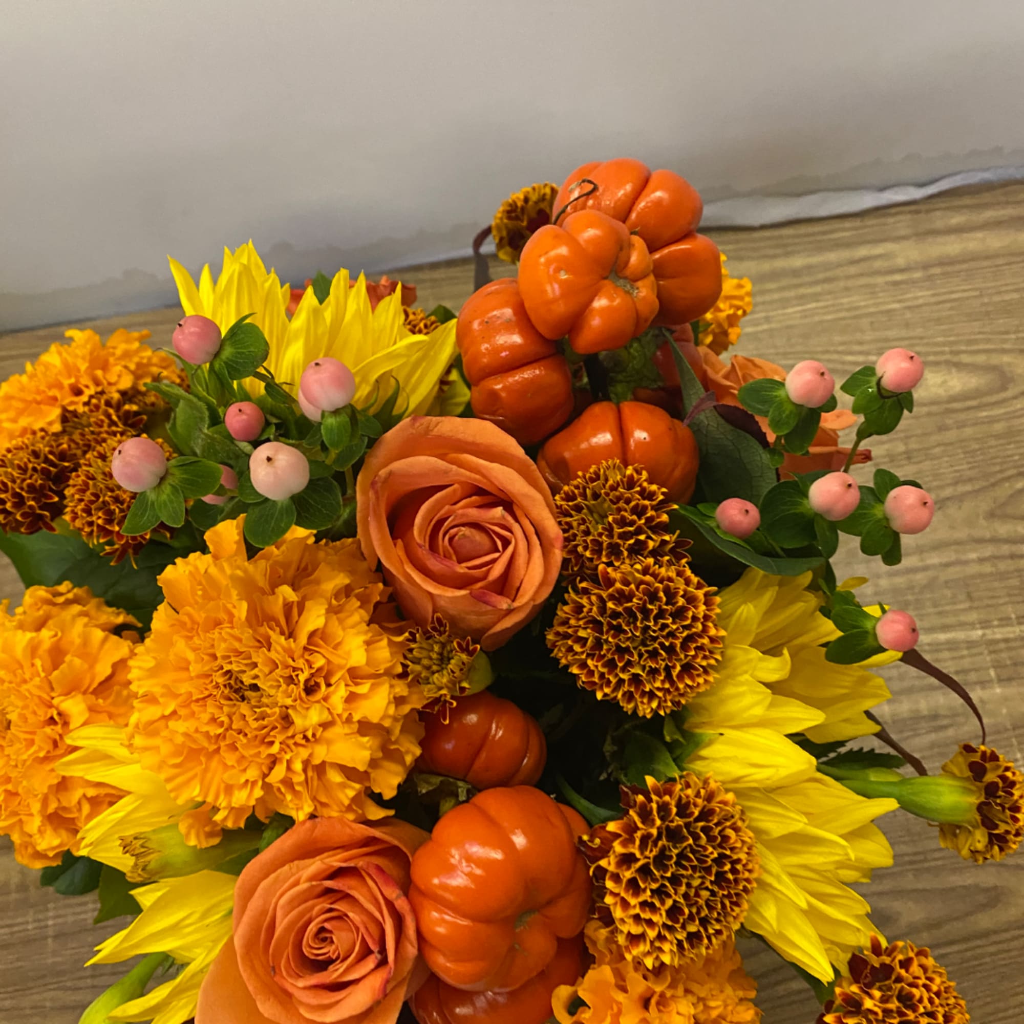 Orange roses and yellow flowers with decorative pumpkins in a bouquet