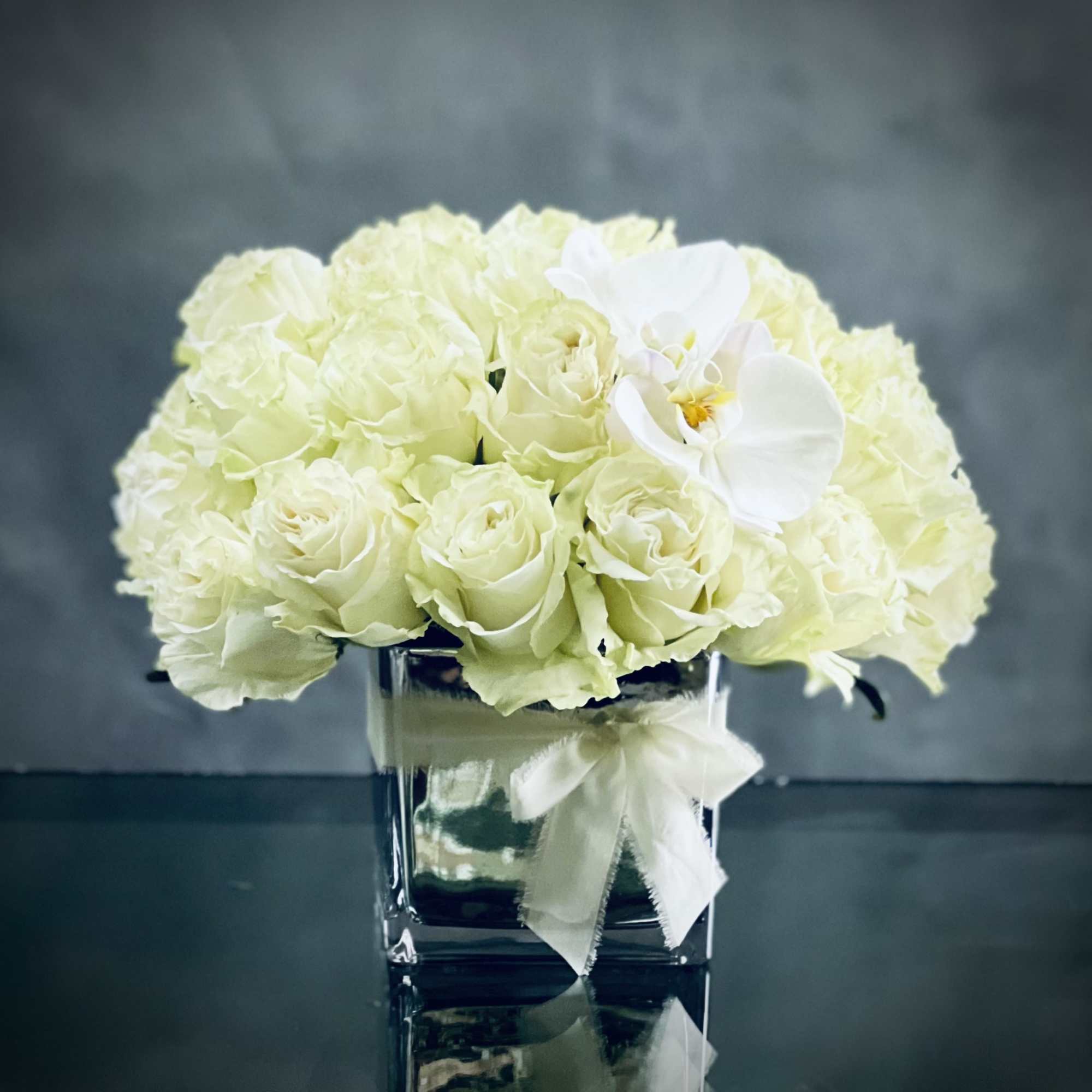 This arrangement has over 36 Blooms of pale green white Roses accented