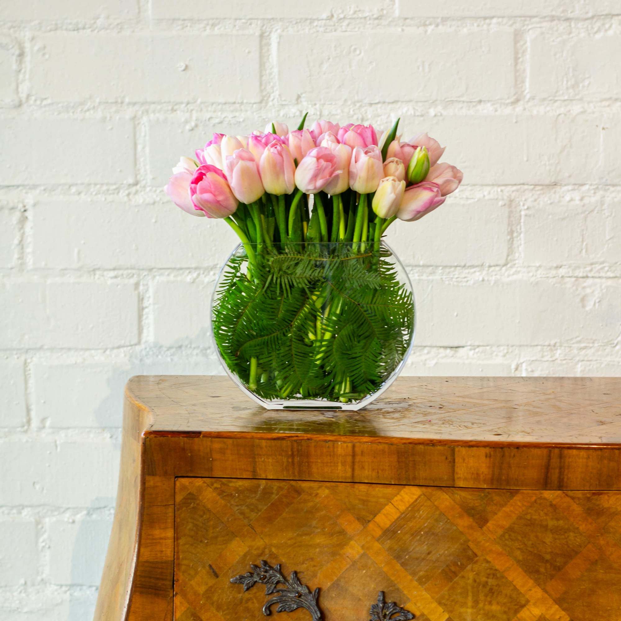 The beautiful arrangement showcases 50 tulips gathered in a modern vase, creating, photo 3 of 5