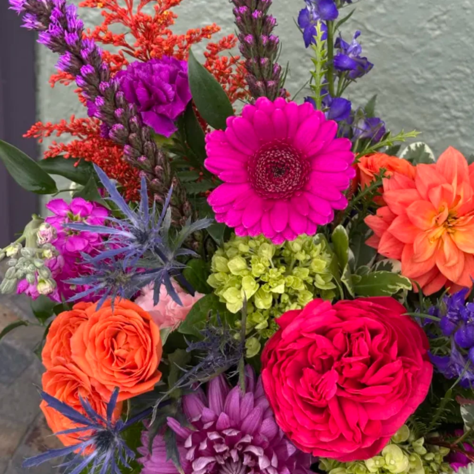 Bright mixed bouquet with gerbera daisies, roses, and purple blooms