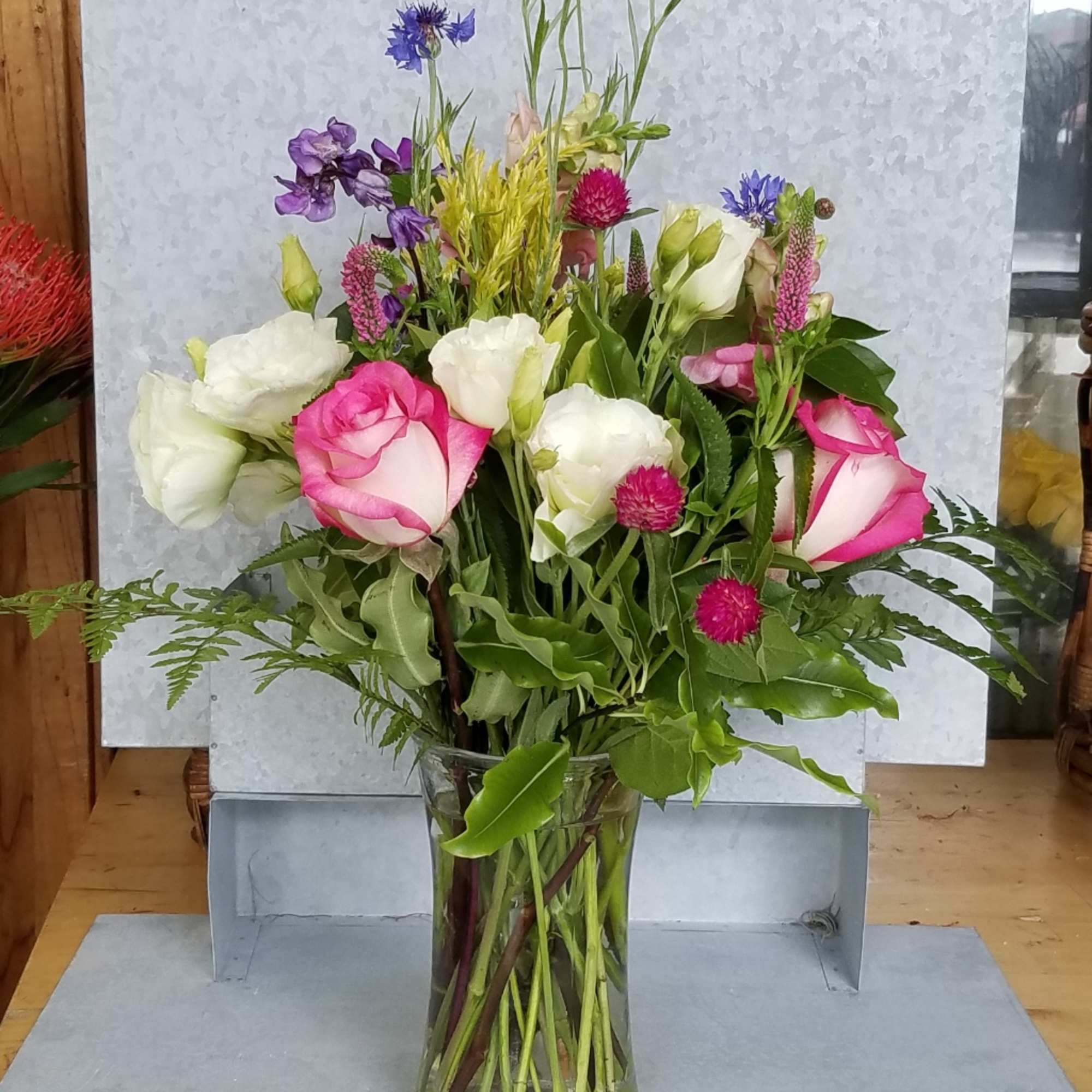 Mixed bouquet of pink and white roses in a clear glass vase