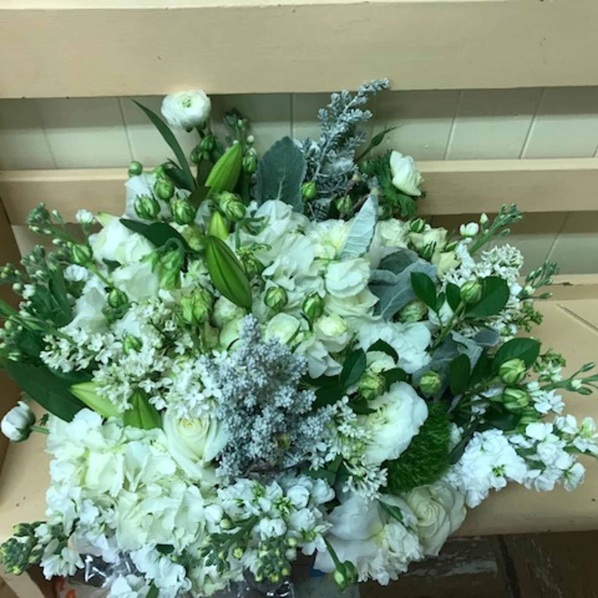 Large white floral arrangement with lilies and roses