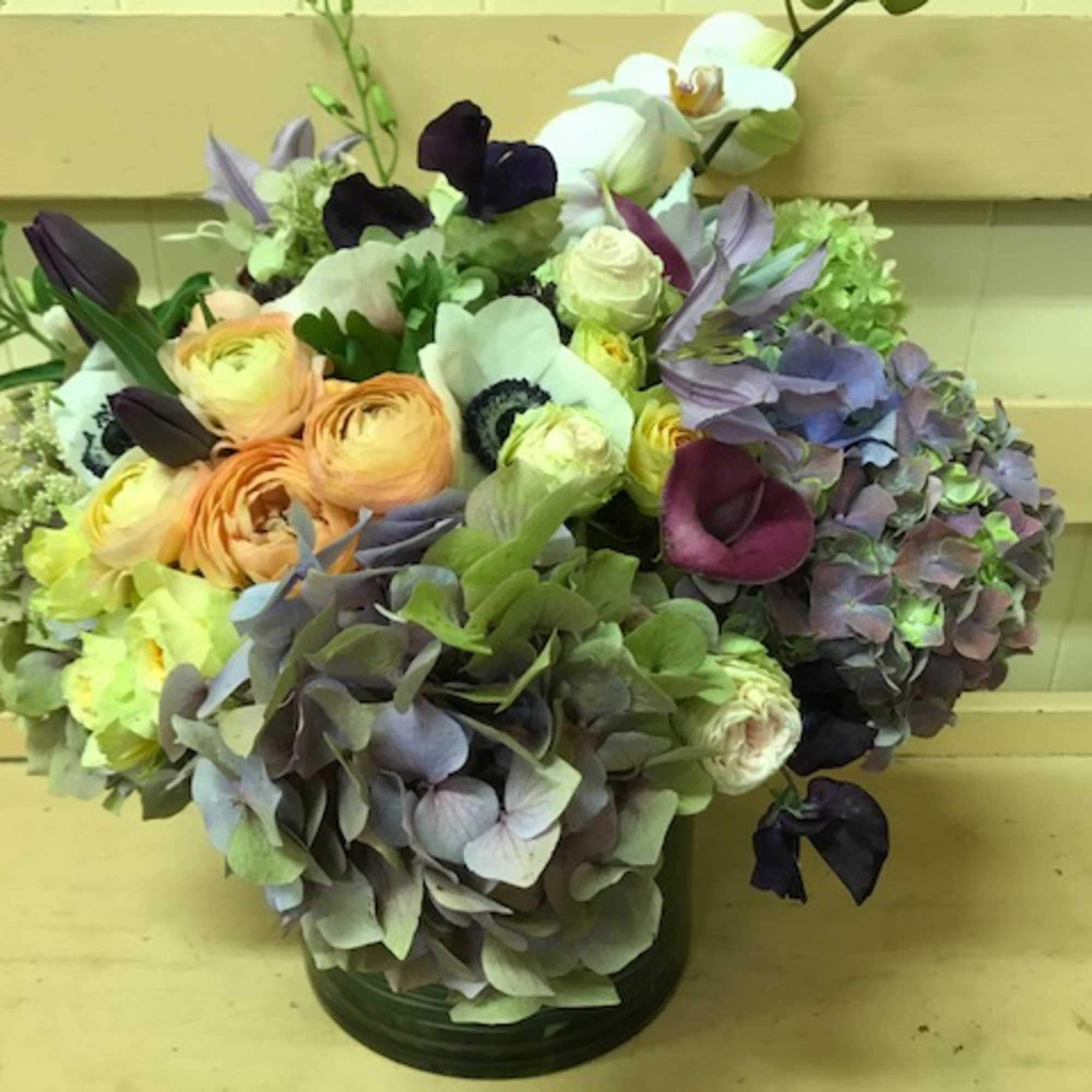 Mixed bouquet with pastel flowers in a green vase