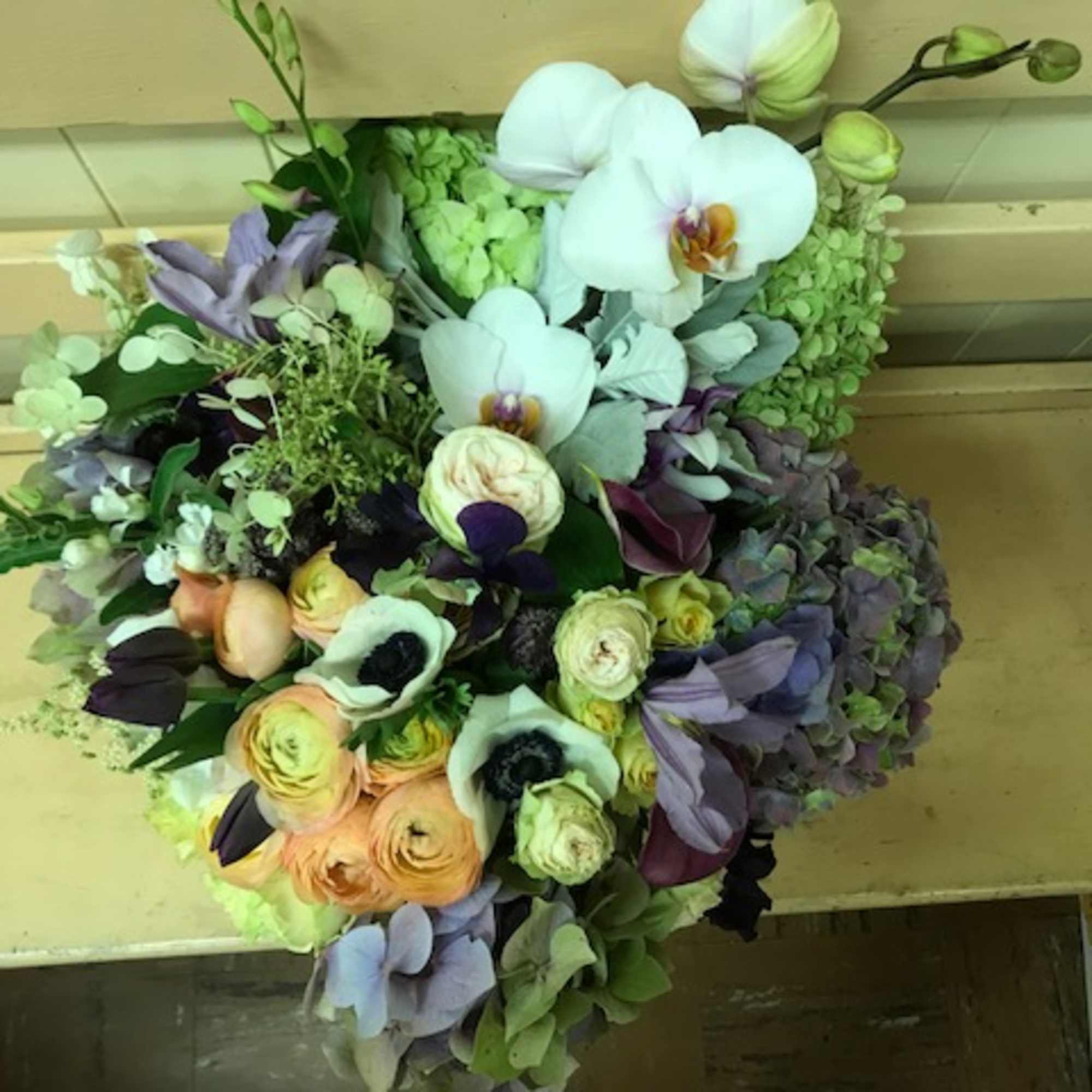 Mixed bouquet with white orchids, ranunculus, and purple hydrangeas