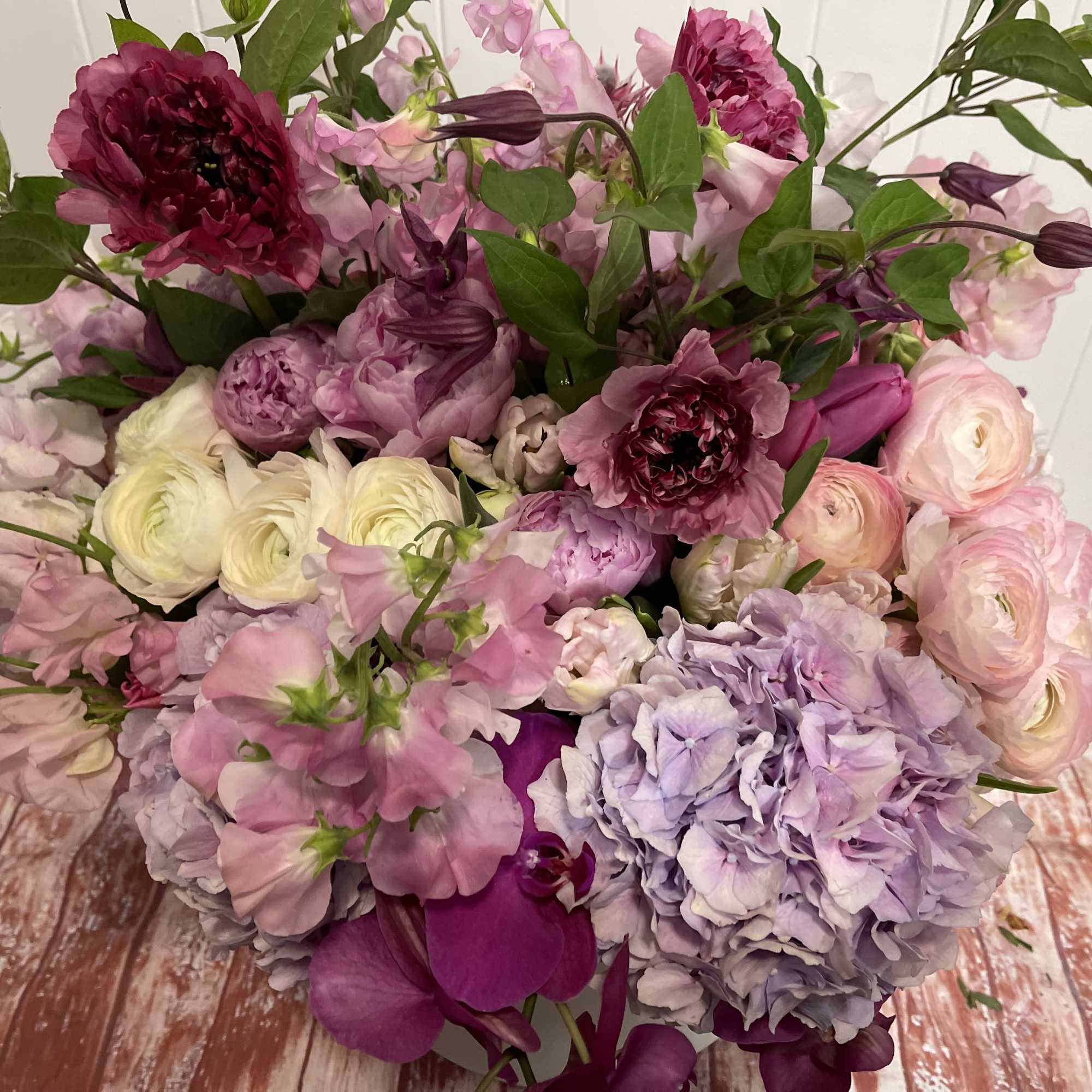 Large bouquet of pink, purple, and white flowers with green foliage