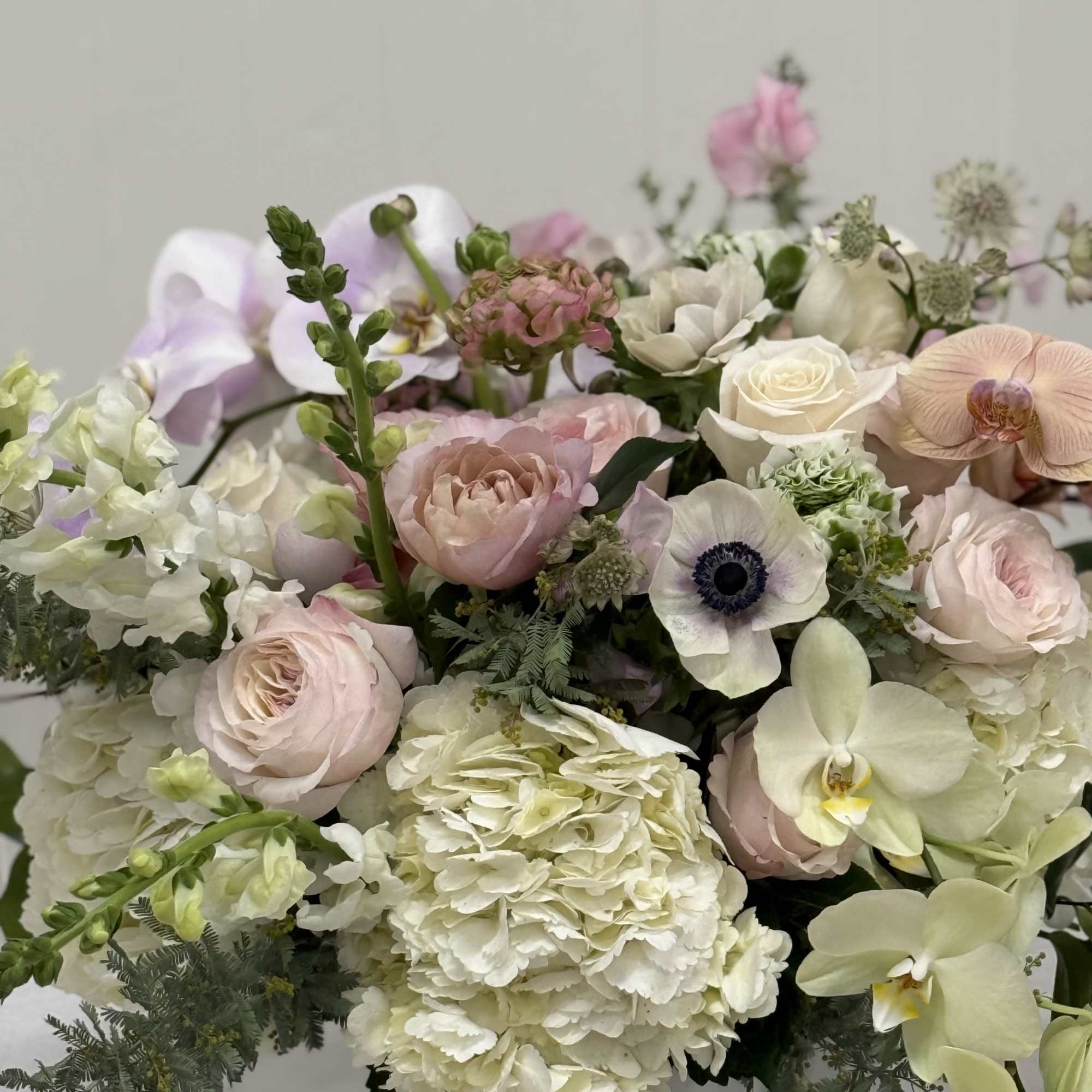 Soft pastel bouquet with roses, hydrangea, orchids, and anemones