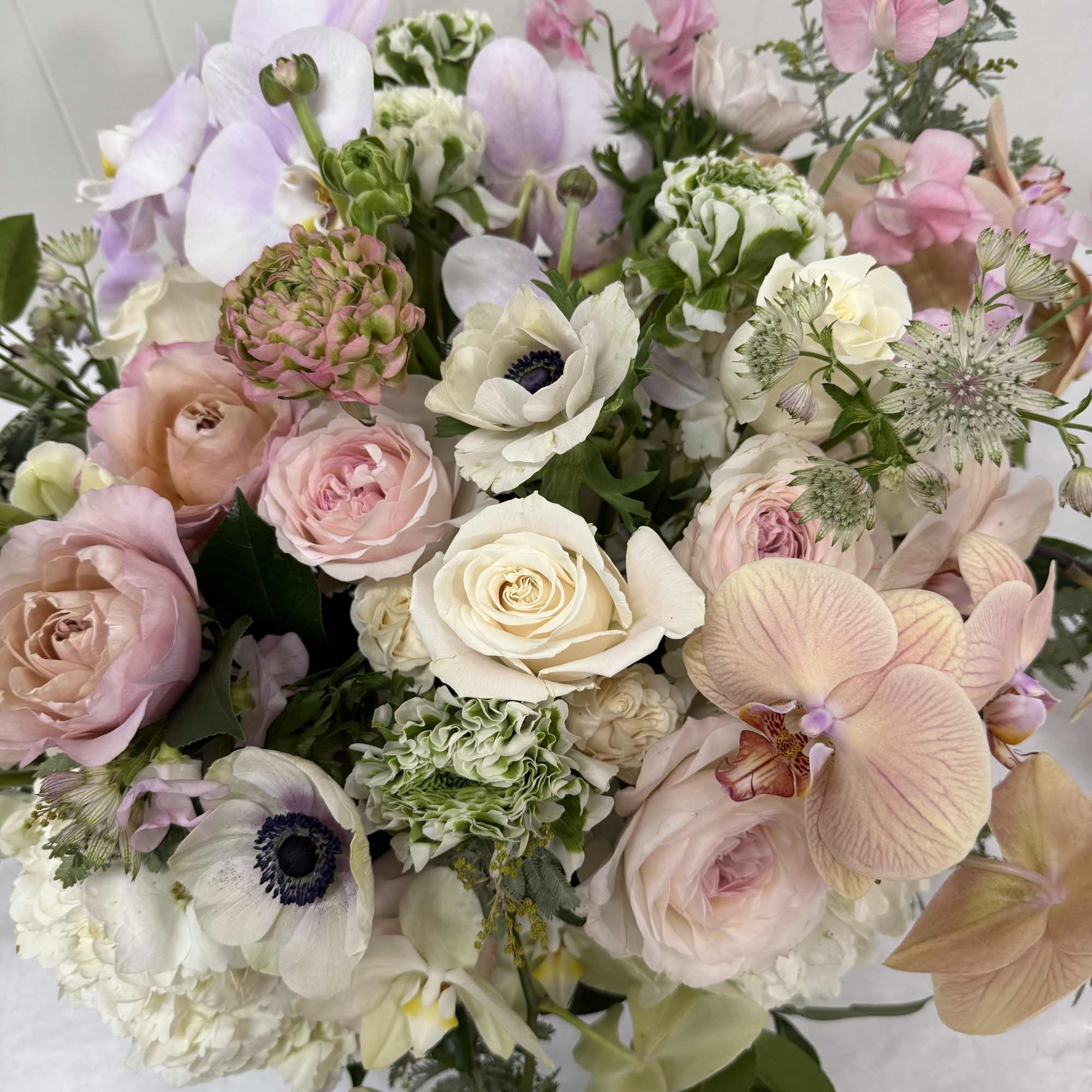 Pastel bouquet with roses, orchids, and anemones