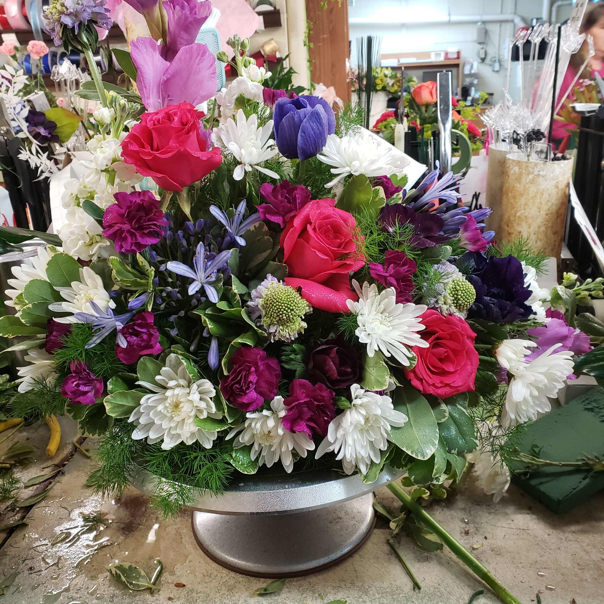 Colorful mixed flower arrangement in a low pedestal container