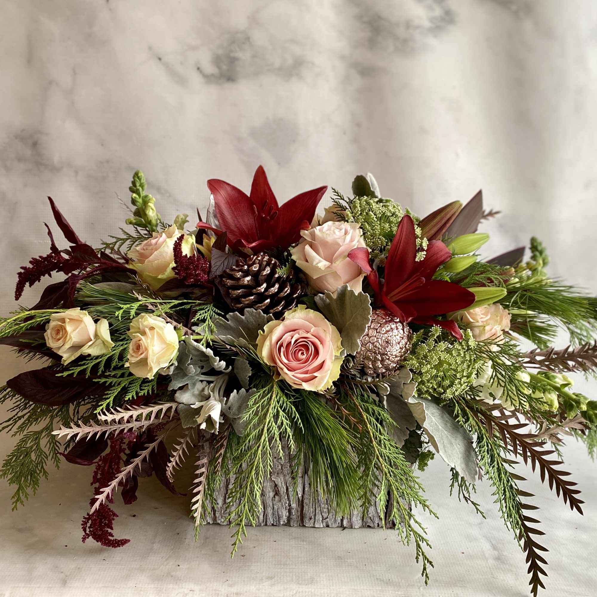 Roses, snap dragons, red lilies, pine cones, Xmas greenery and hanging amaranthus, photo 2 of 2