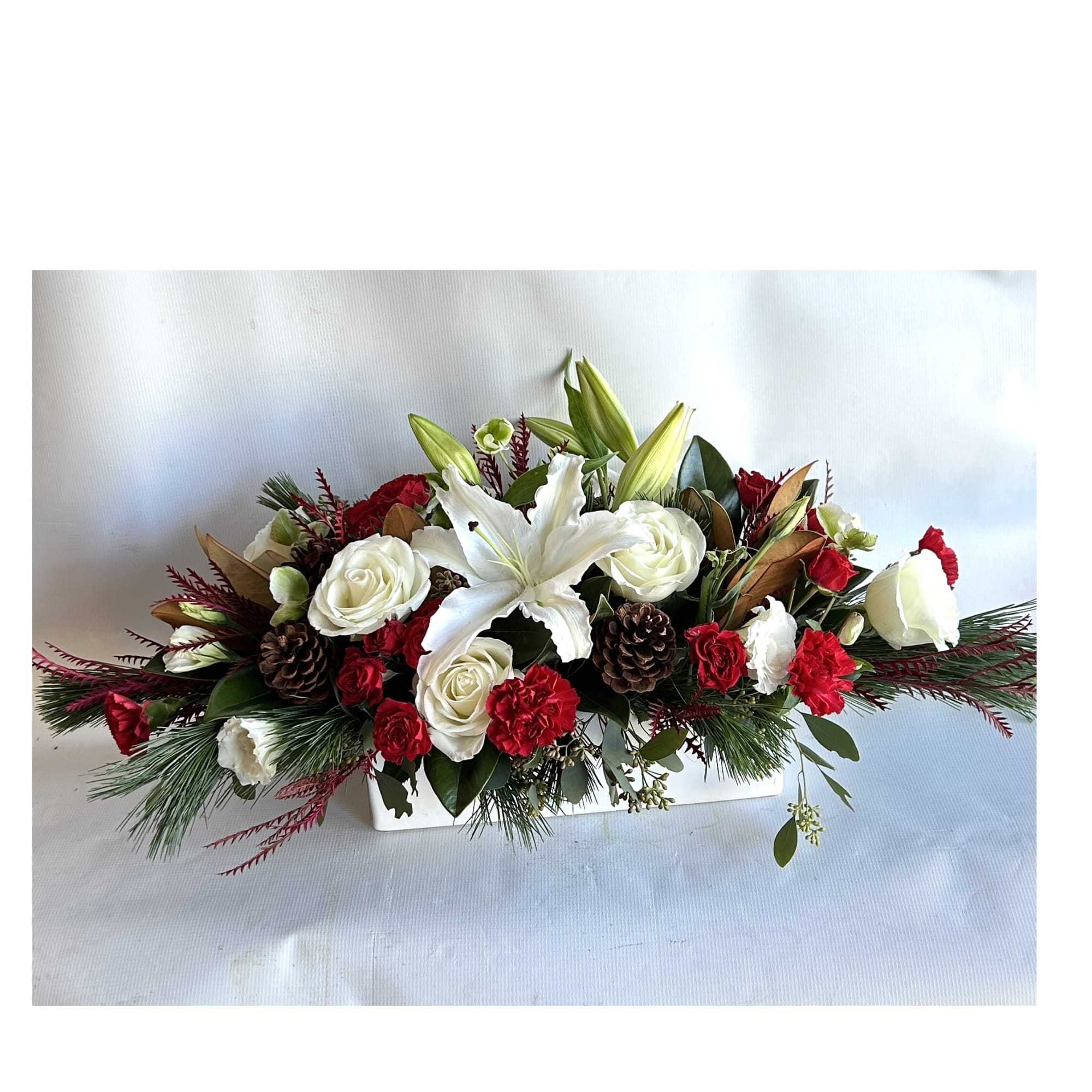 A Holiday arrangement with red roses, orchids, hanging amaranthus, stargazer lilies, dianthus