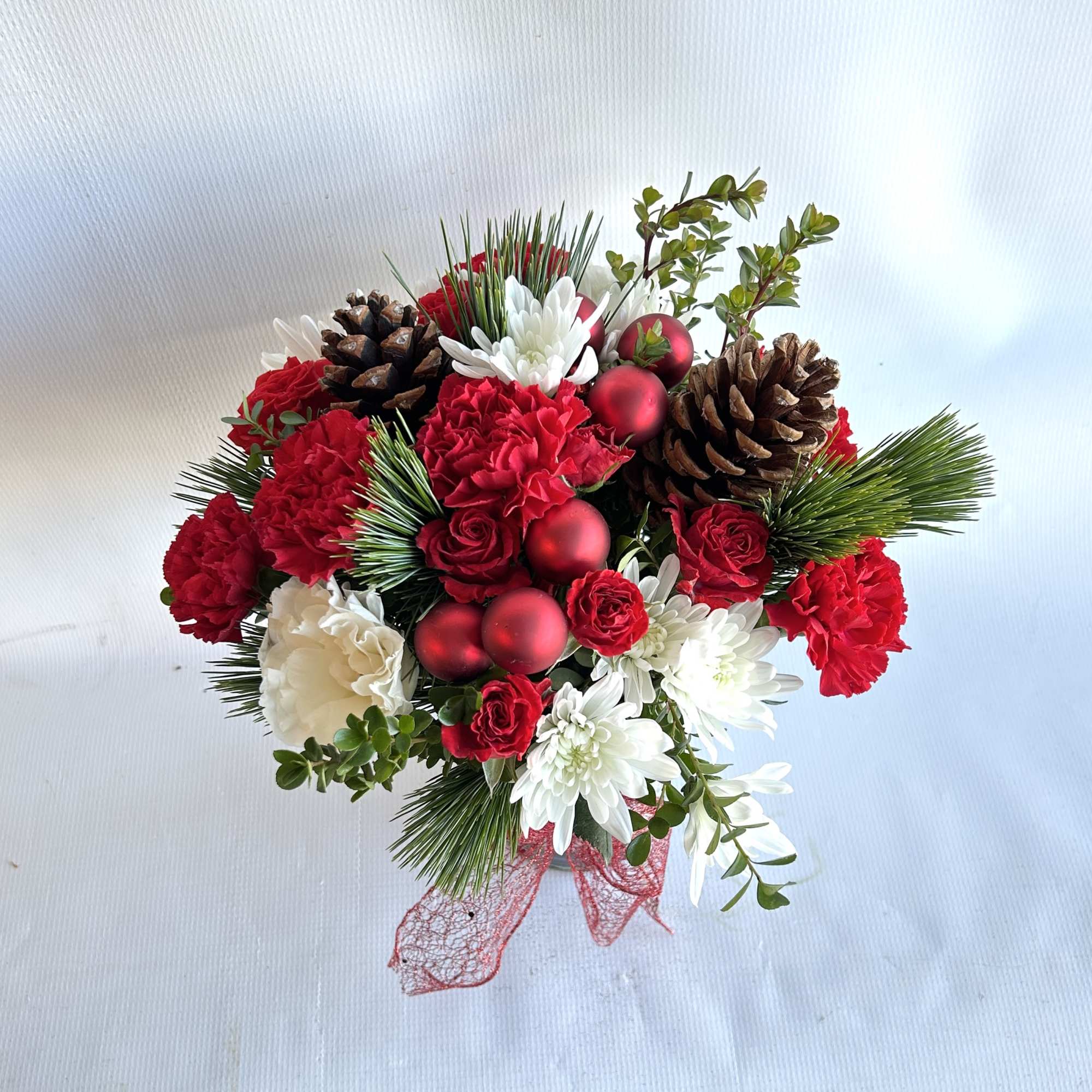 This arrangement is set in a ceramic container, with red roses, hanging