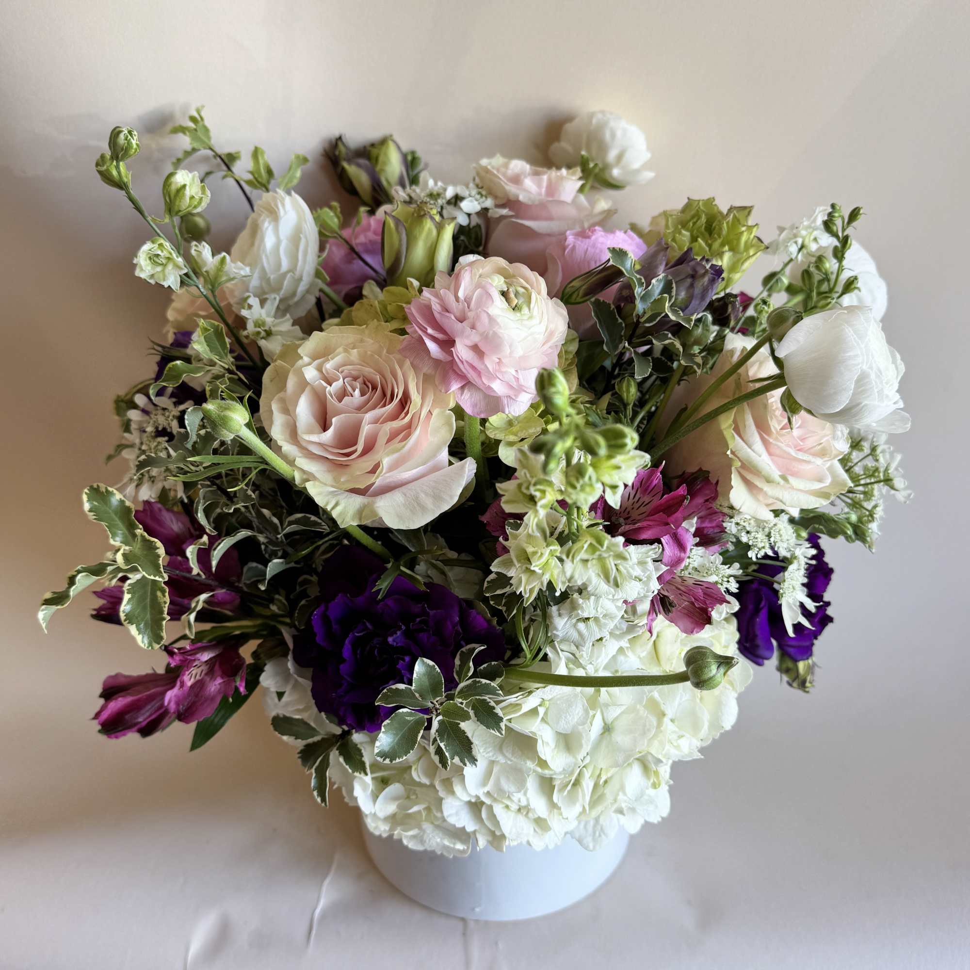 A romantic and elegant floral arrangement bursts with soft, complementary hues of, photo 2 of 3