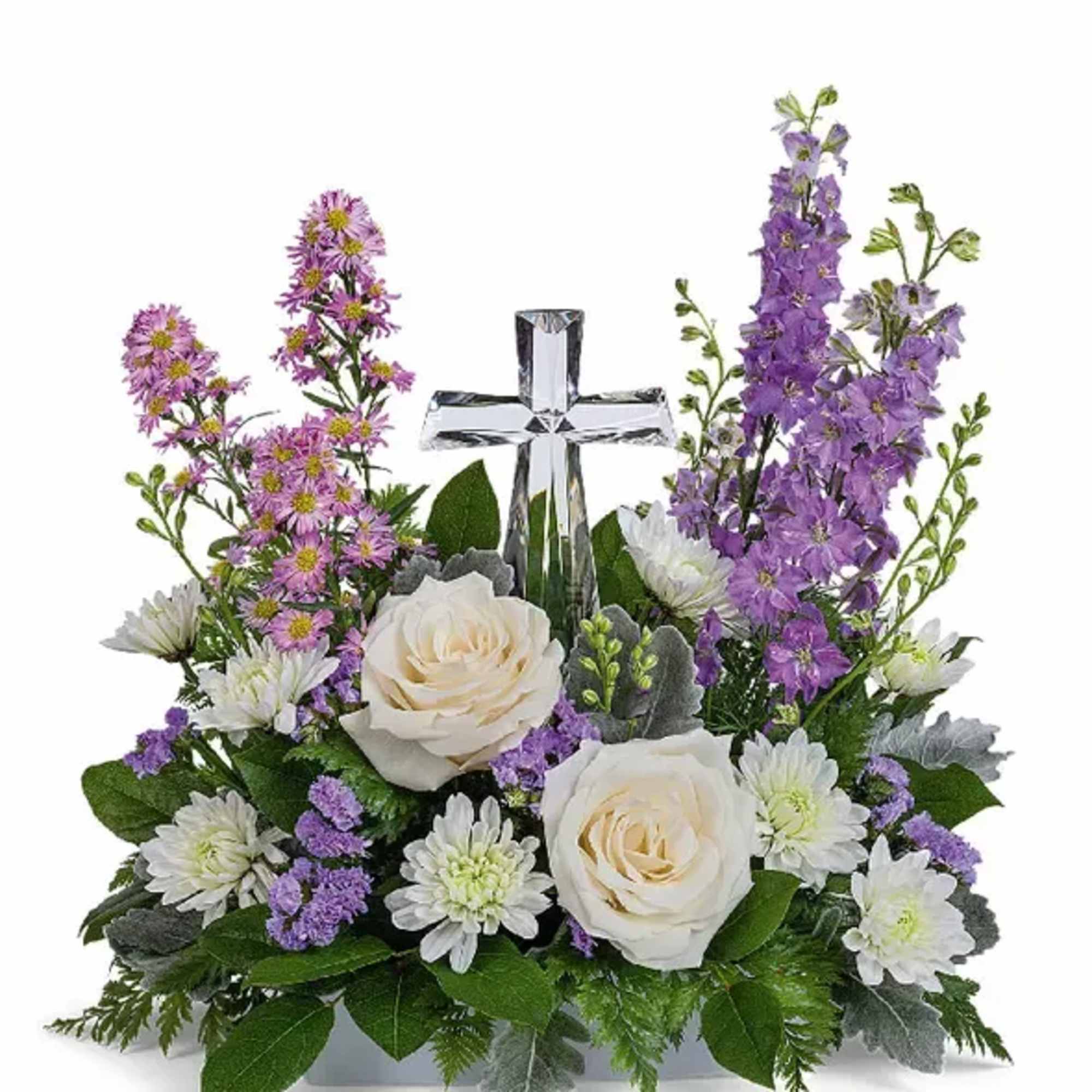 White roses and purple flowers arranged around a clear glass cross