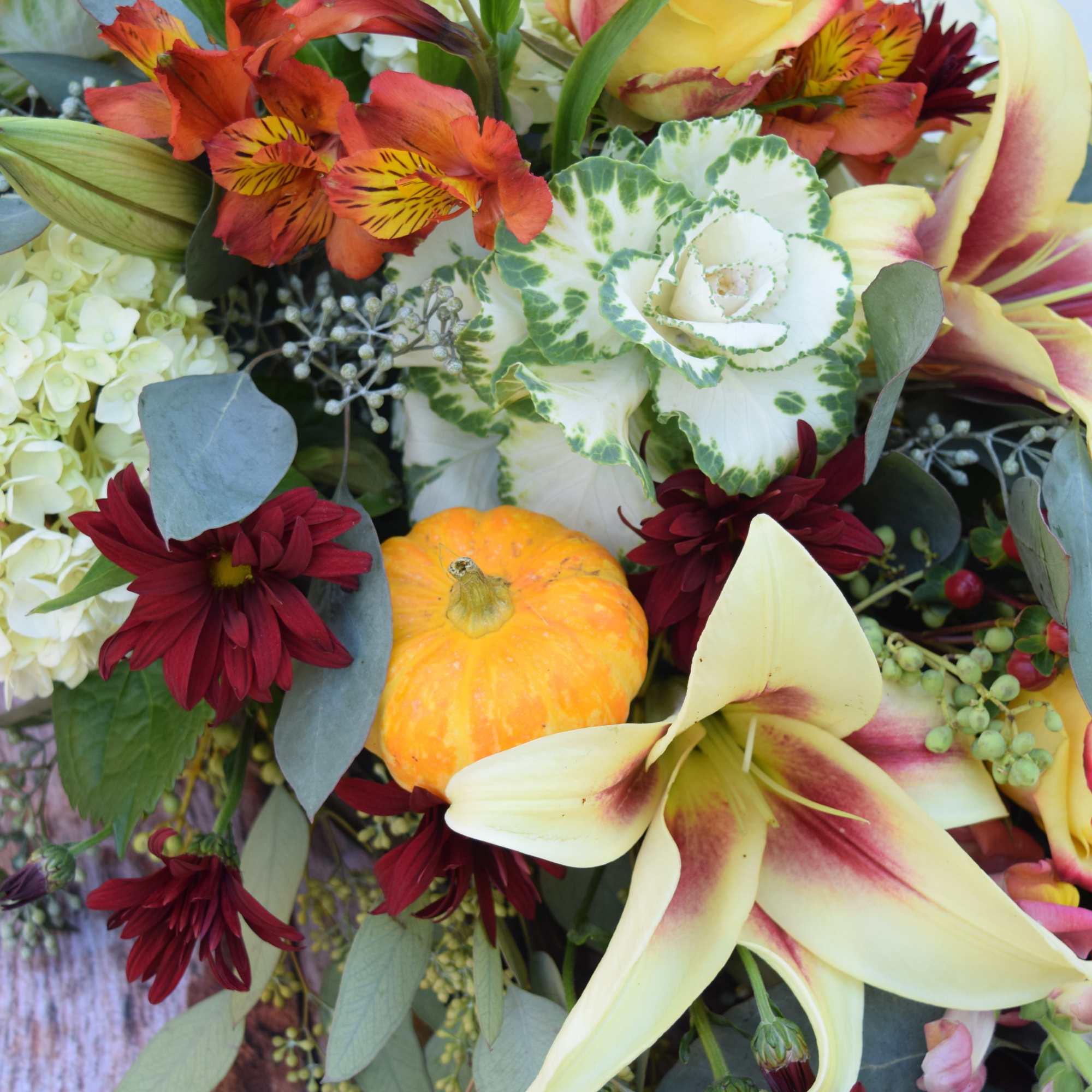 Mixed bouquet with lilies, roses, chrysanthemums, and small pumpkins