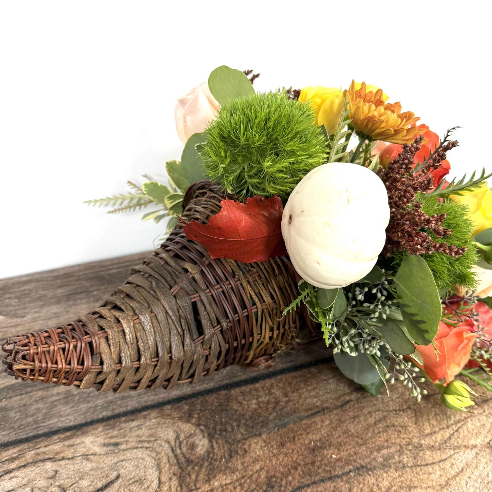Basket arrangement with orange, yellow, and white flowers