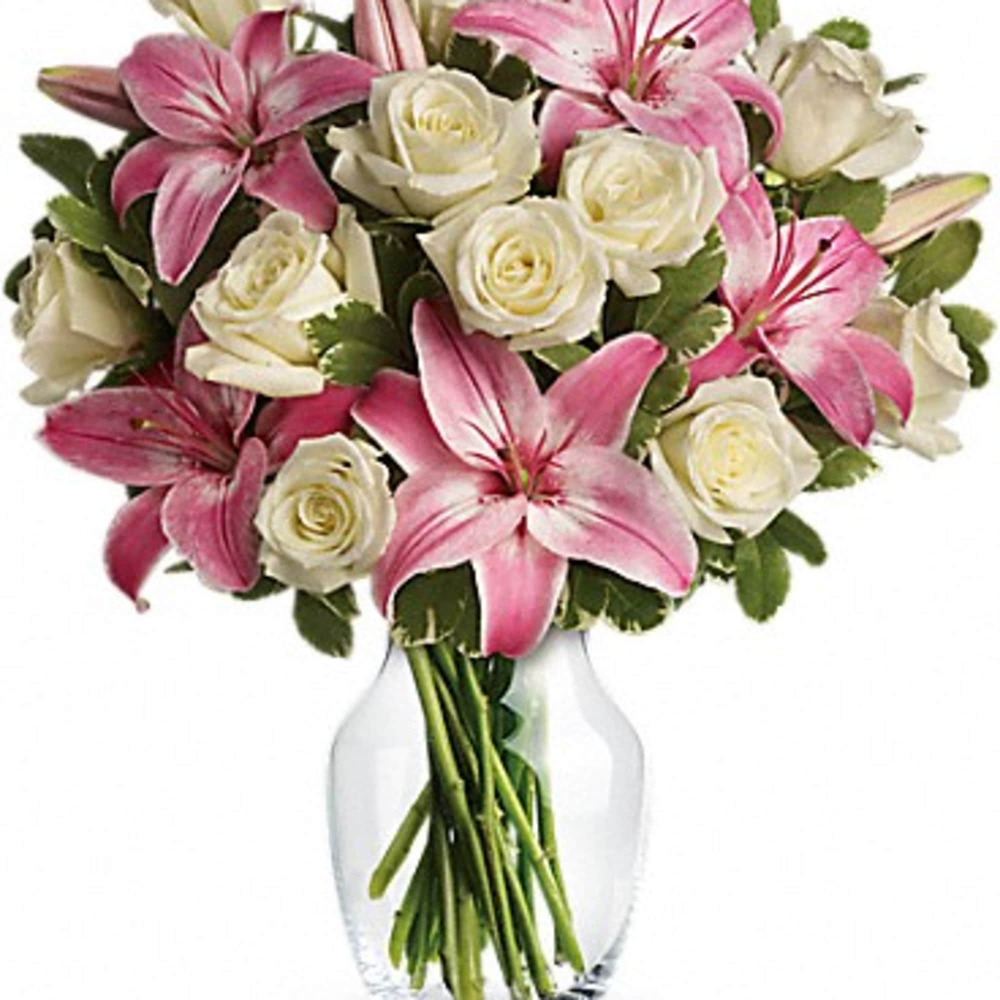Pink lilies and white roses arranged in a clear glass vase