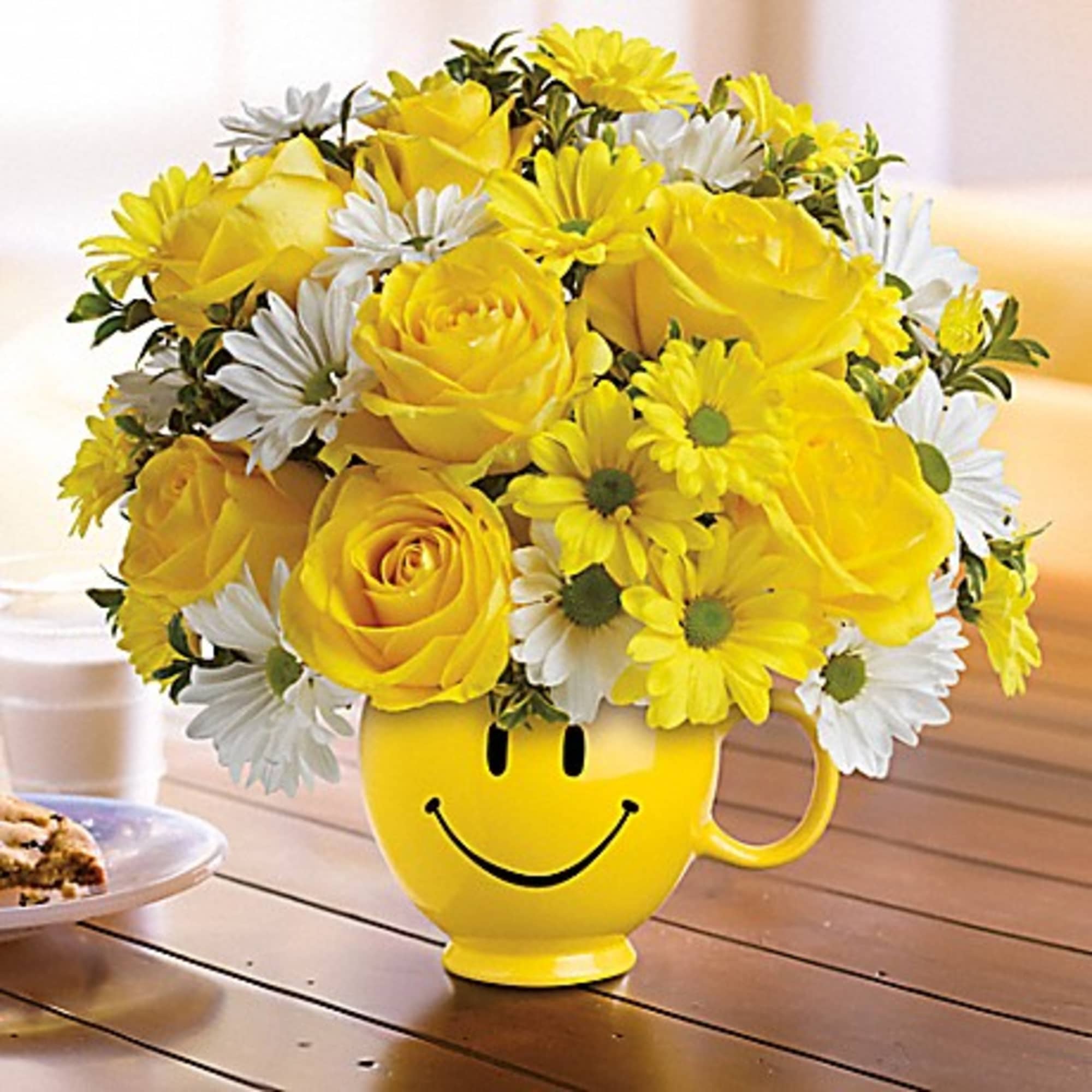 Yellow and white flower bouquet in a smiley-face mug