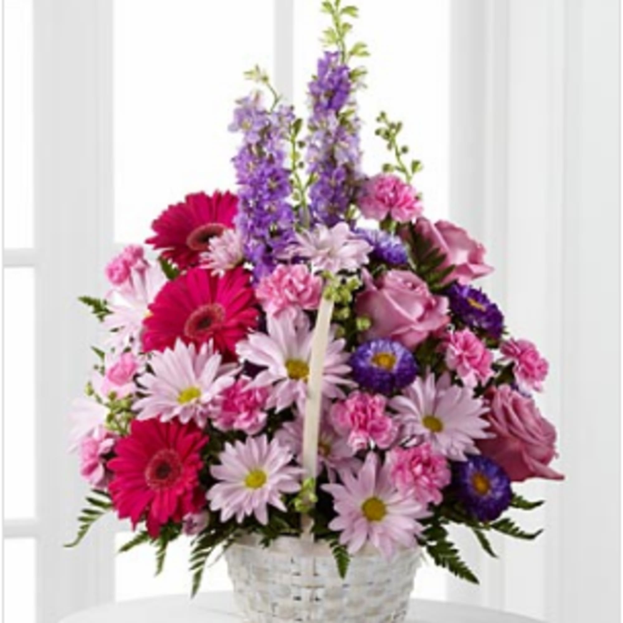 Basket arrangement of pink, purple, and white flowers