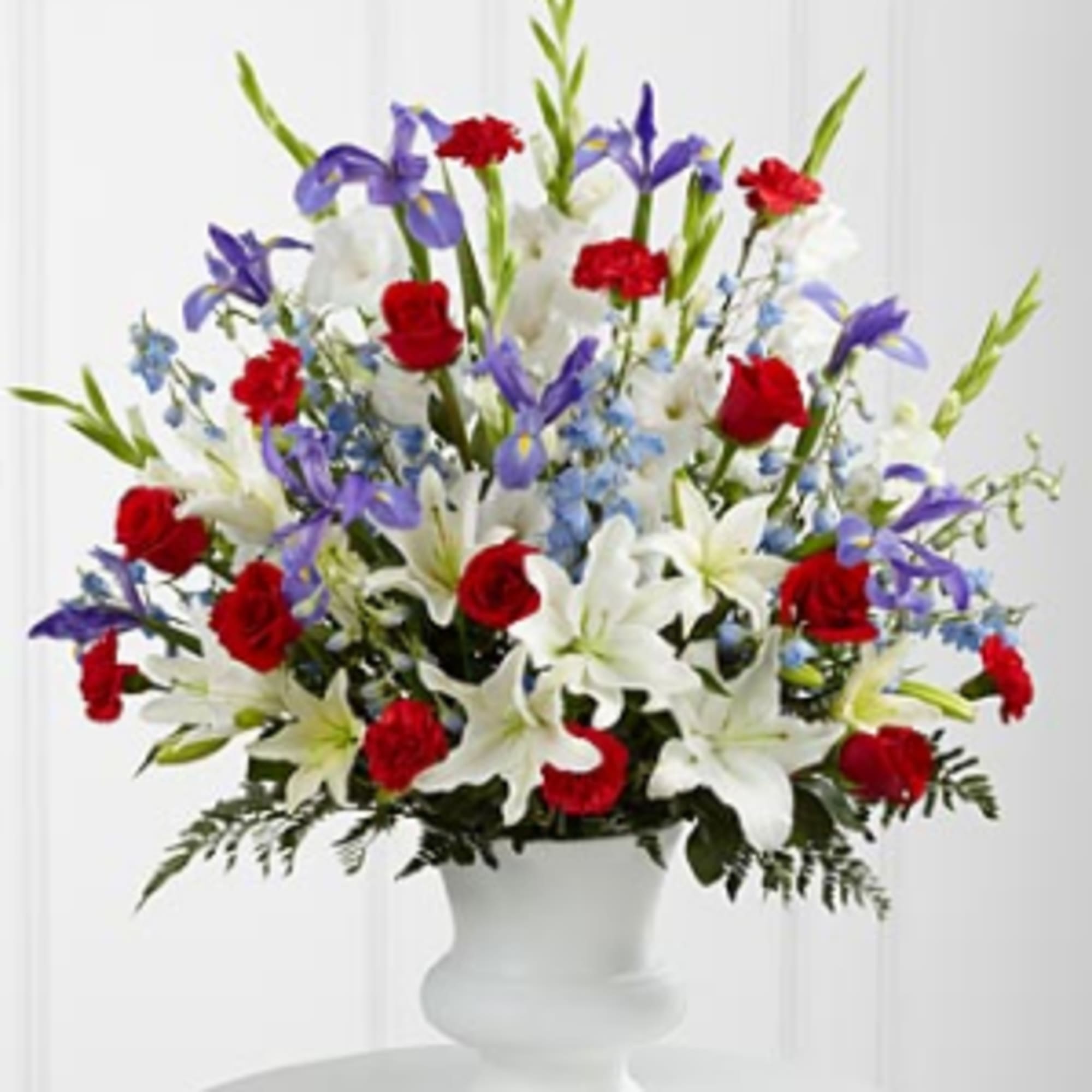 Red roses, white lilies, and purple irises in a white vase