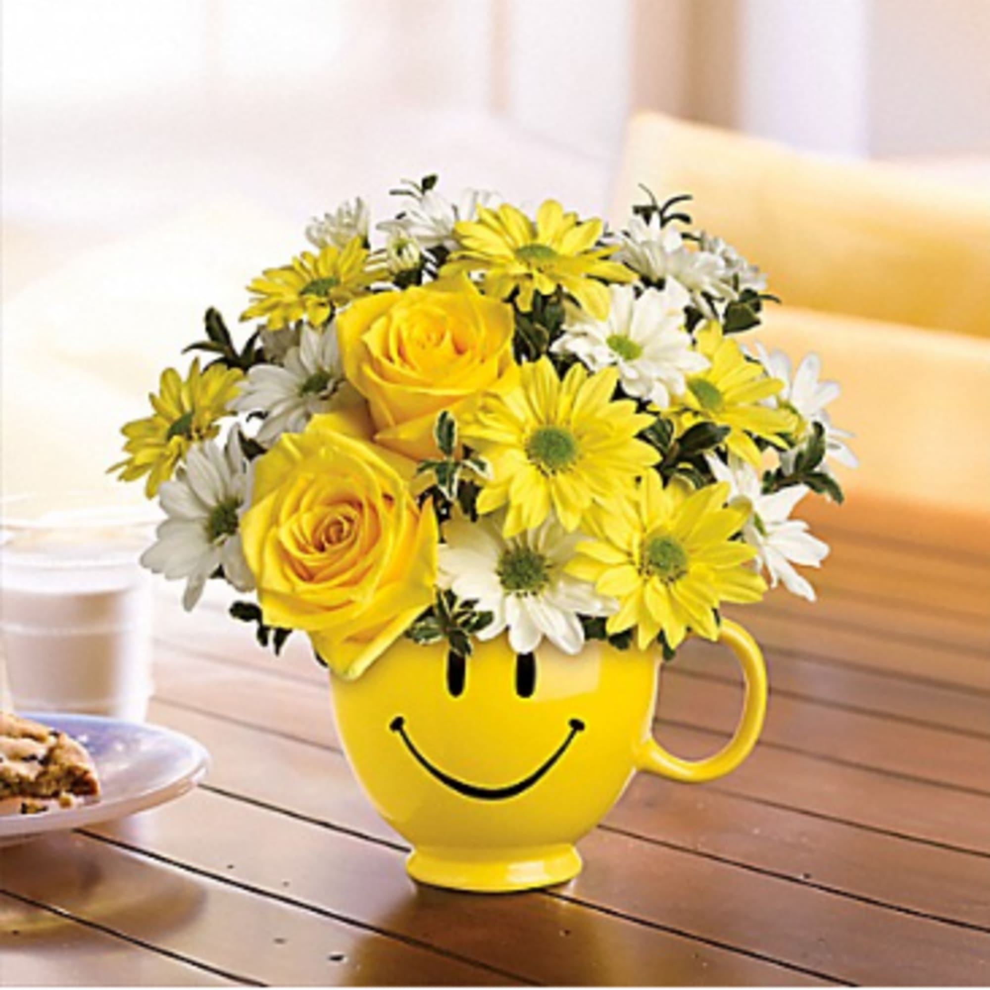 Yellow and white flowers in a smiley-face mug vase