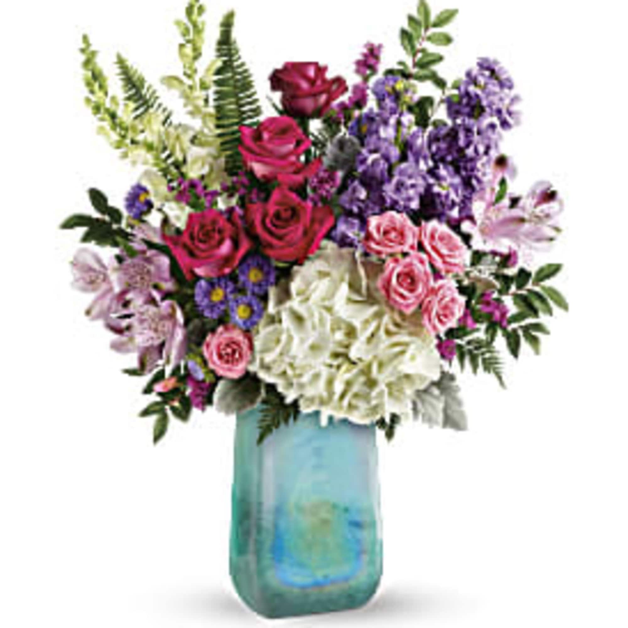 Mixed bouquet of roses, hydrangeas, and purple flowers in a blue glass vase